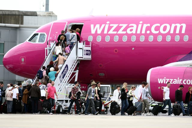 <p>Passengers scramble aboard a Wizz Air aircraft at London Luton airport, where it serves 75 destinations</p>