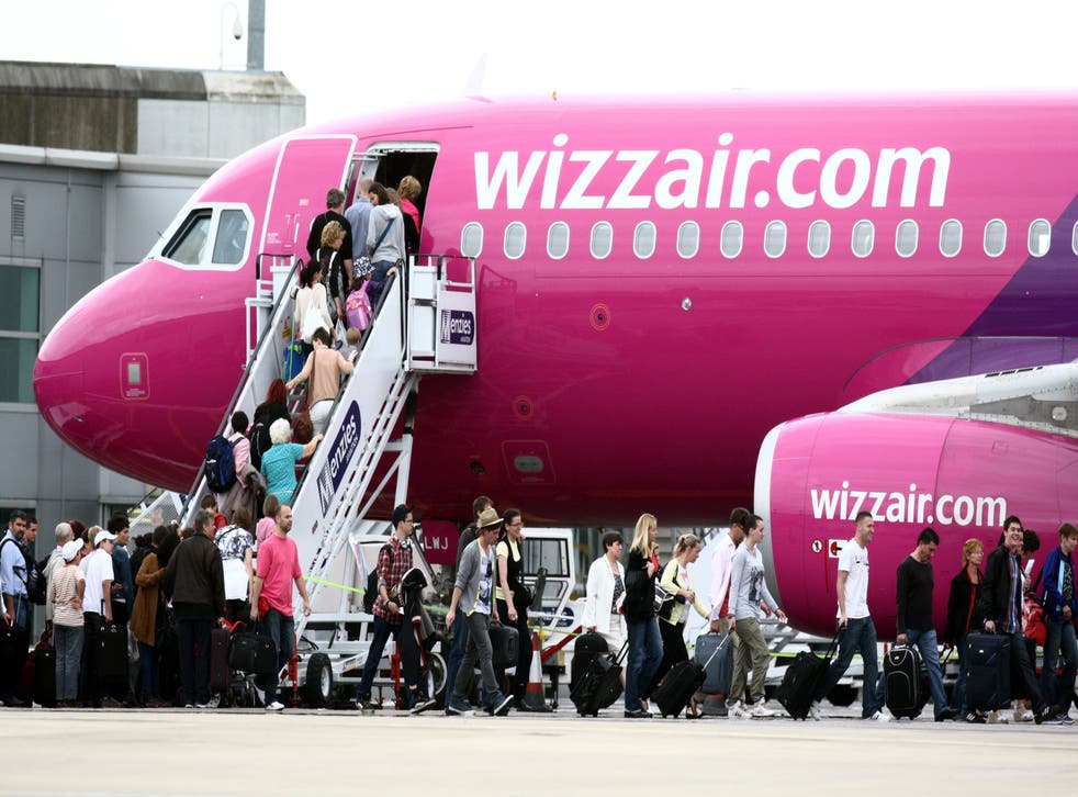 <p>Passengers scramble aboard a Wizz Air aircraft at London Luton airport, where it serves 75 destinations</p>