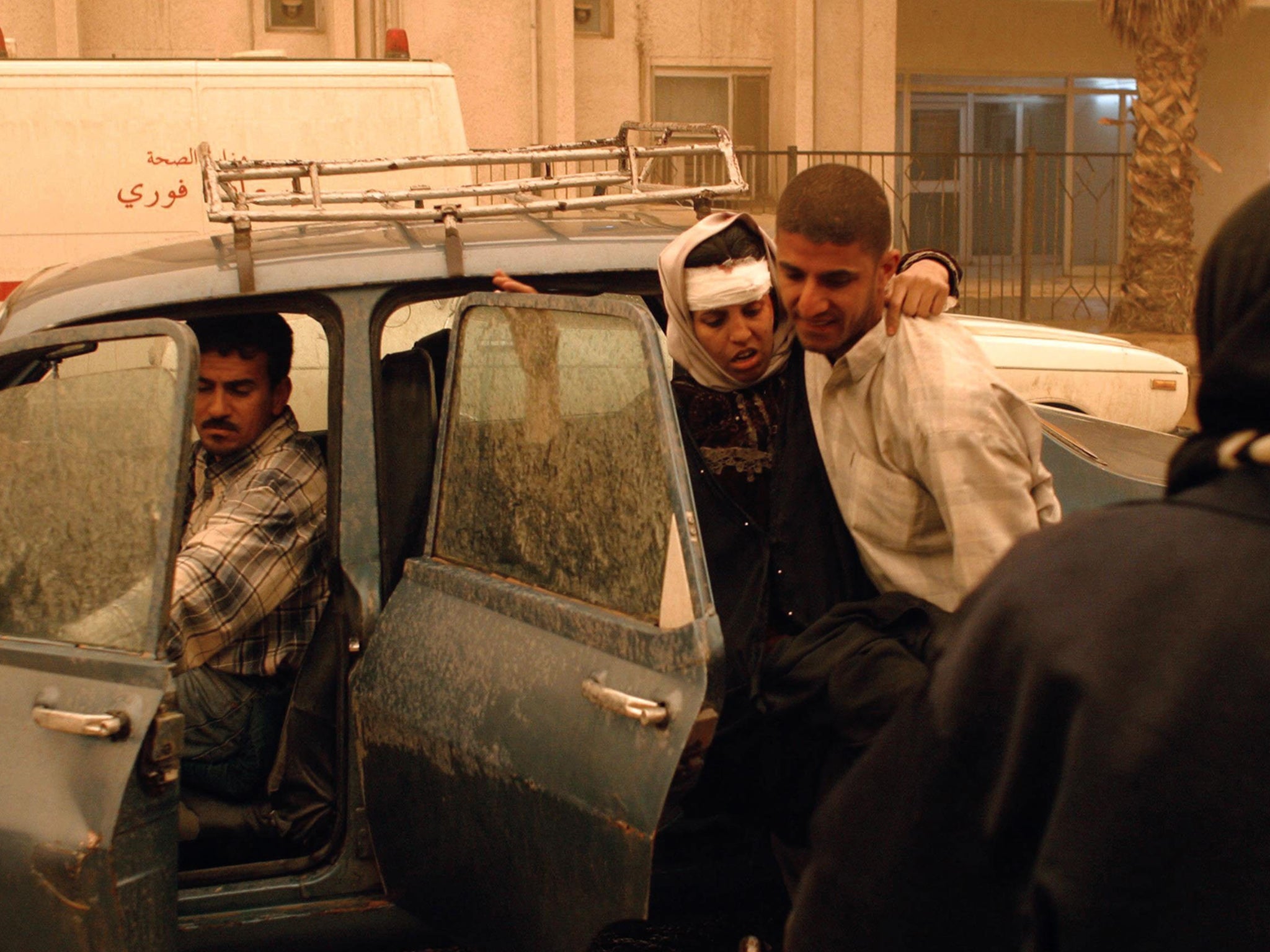 The injured are helped away after one of several US missile attacks in Baghdad on 26 March 2003