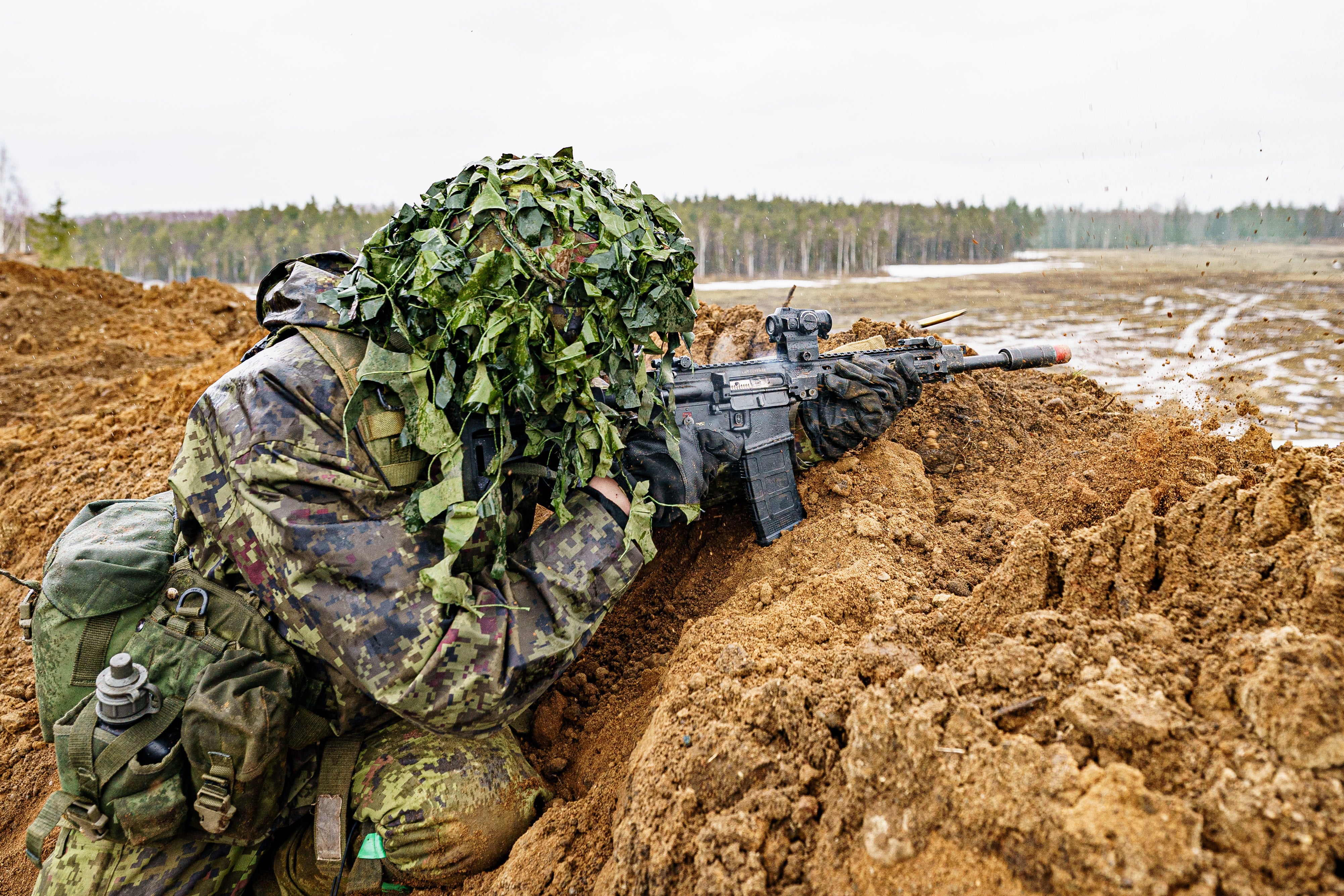 Estonian soldiers defend a dug-in position attacked by British troops at the Tapa central military training area in Estonia on NATO exercise Bold Dragon alongside, Danish and French forces (Ben Birchall/PA)