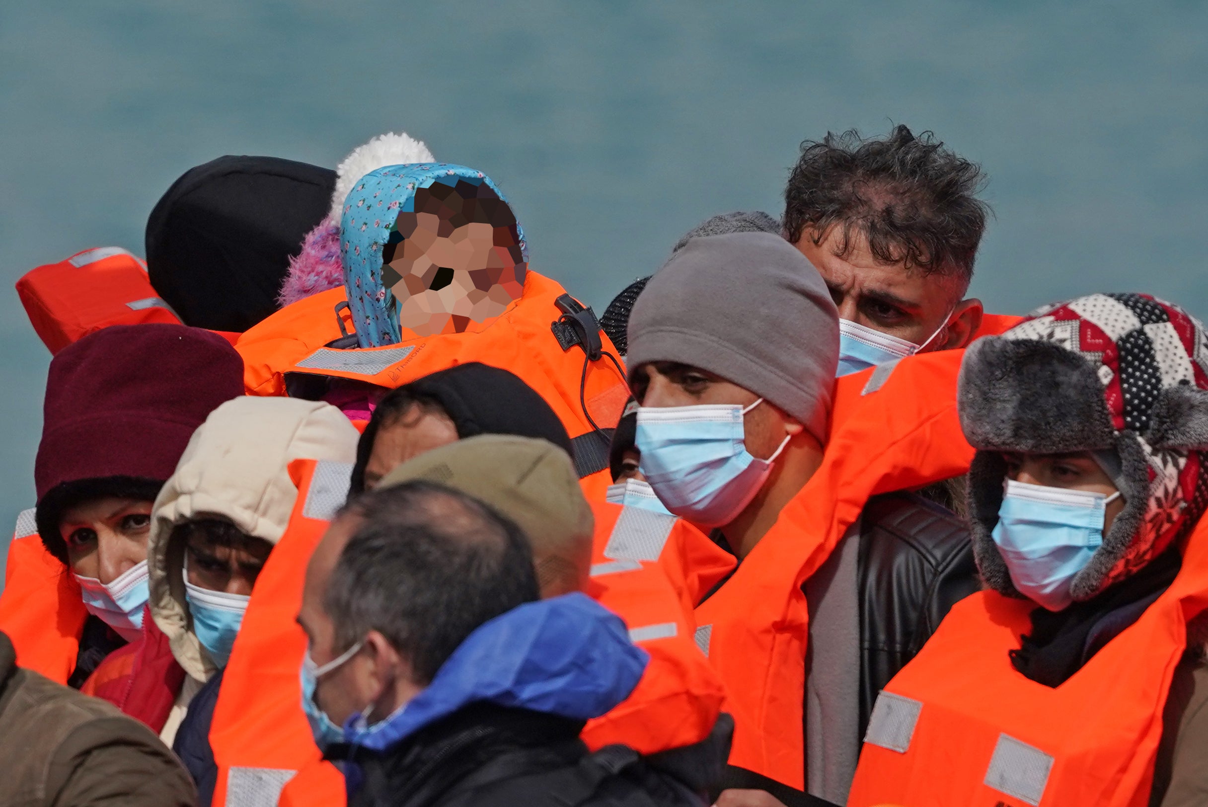 A young child (face pixelated) amongst a group of people thought to be migrants are brought in to Dover, Kent, following a small boat incident in the Channel (Gareth Fuller/PA)