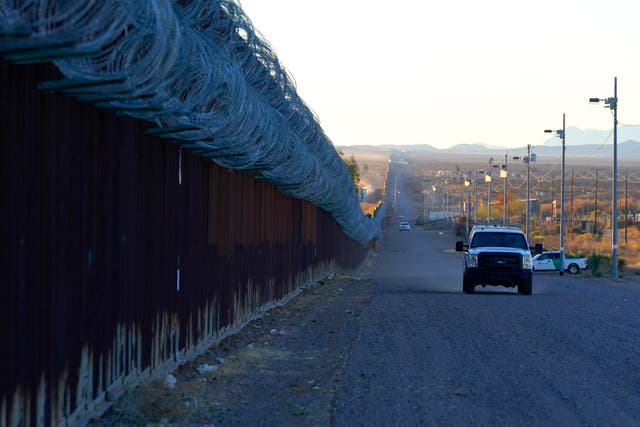 <p> A US Border Patrol vehicle drives along the border fence at the US- Mexico border wall</p>