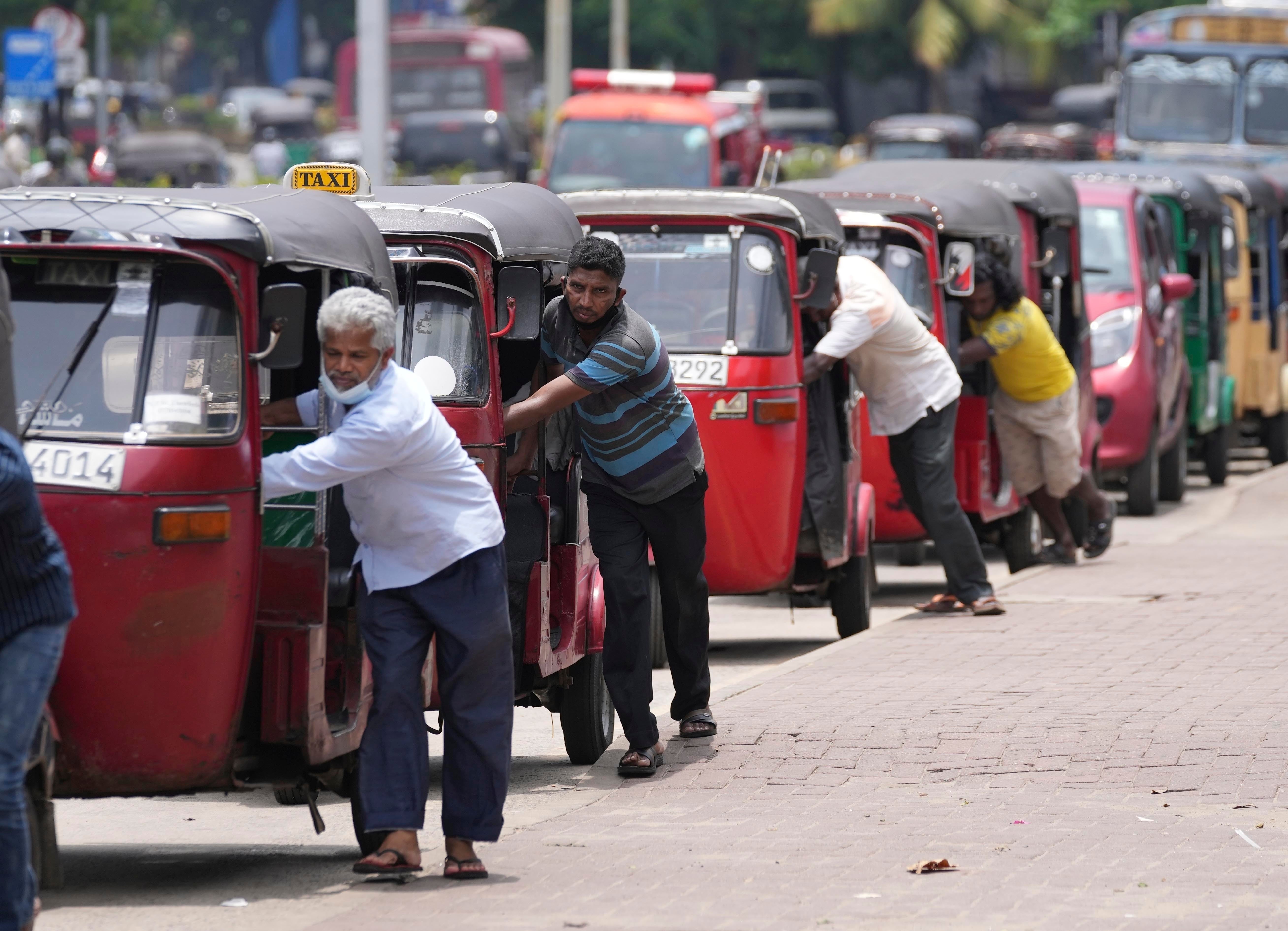<p>File photo: Sri Lankan auto rickshaw drivers queue up to buy petrol near a fuel station in Colombo, on 13 April 2022</p>