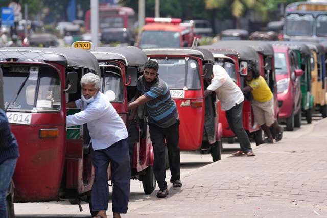 <p>File photo: Sri Lankan auto rickshaw drivers queue up to buy petrol near a fuel station in Colombo, on 13 April 2022</p>