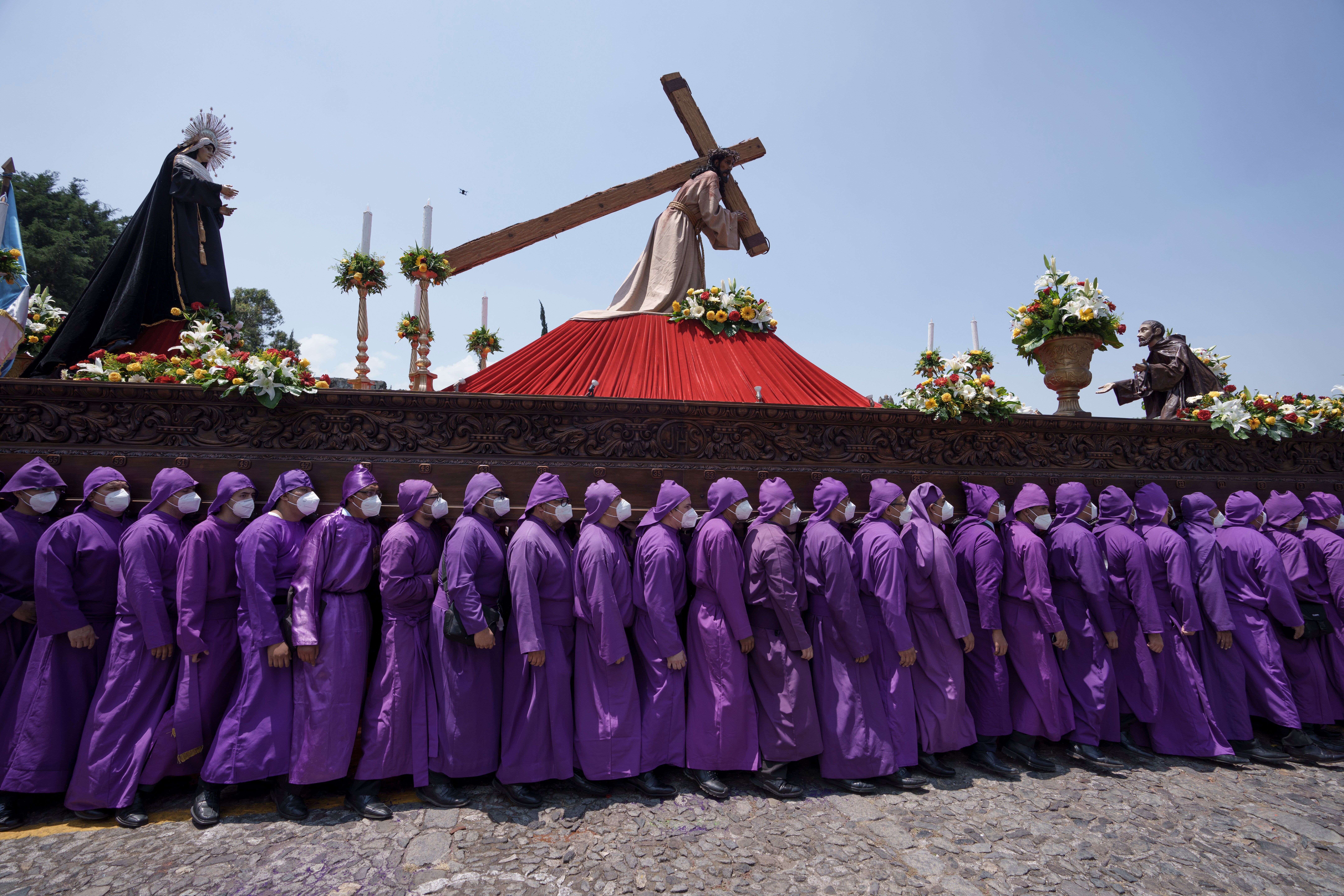 "Cucuruchos" carry a statue of Jesus Christ on a religious float during a Holy Thursday procession, in Antigua, Guatemala