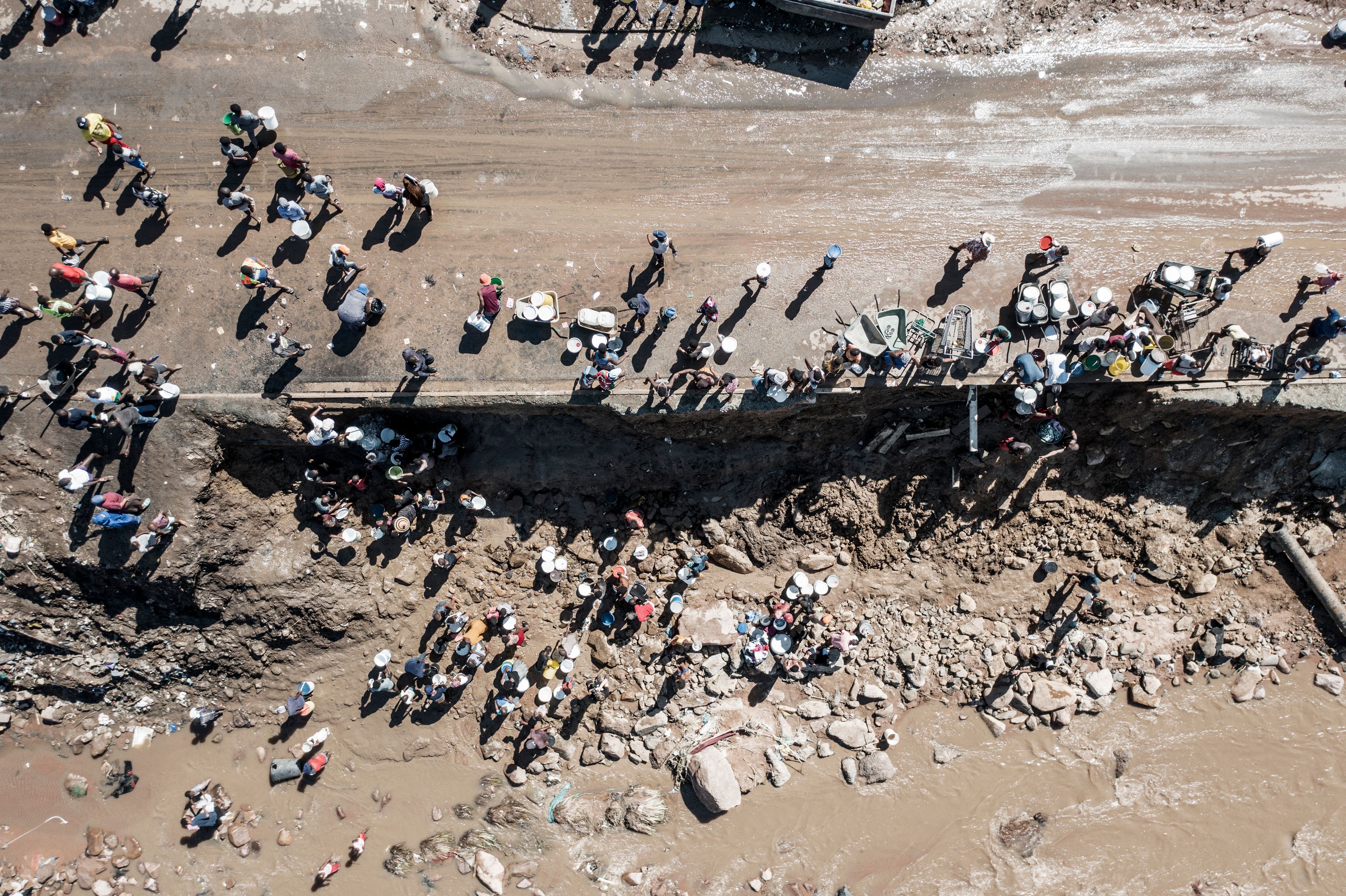 Residents of Amaoti, a township north of Durban, collect clean water from a broken pipe