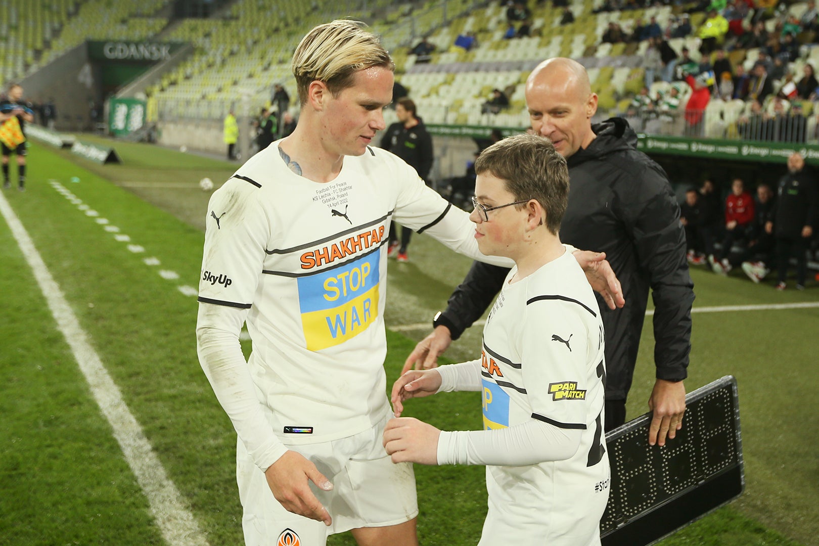 12-year-old Dmytro Keda is welcomed onto the pitch by midfielder Mykhaylo Mudryk (Shakhtar Donetsk/PA)
