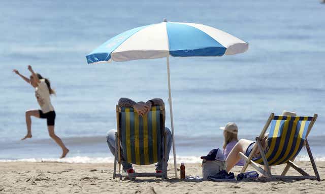 People enjoy the warm weather on Bournemouth beach (Andrew Matthews/PA)