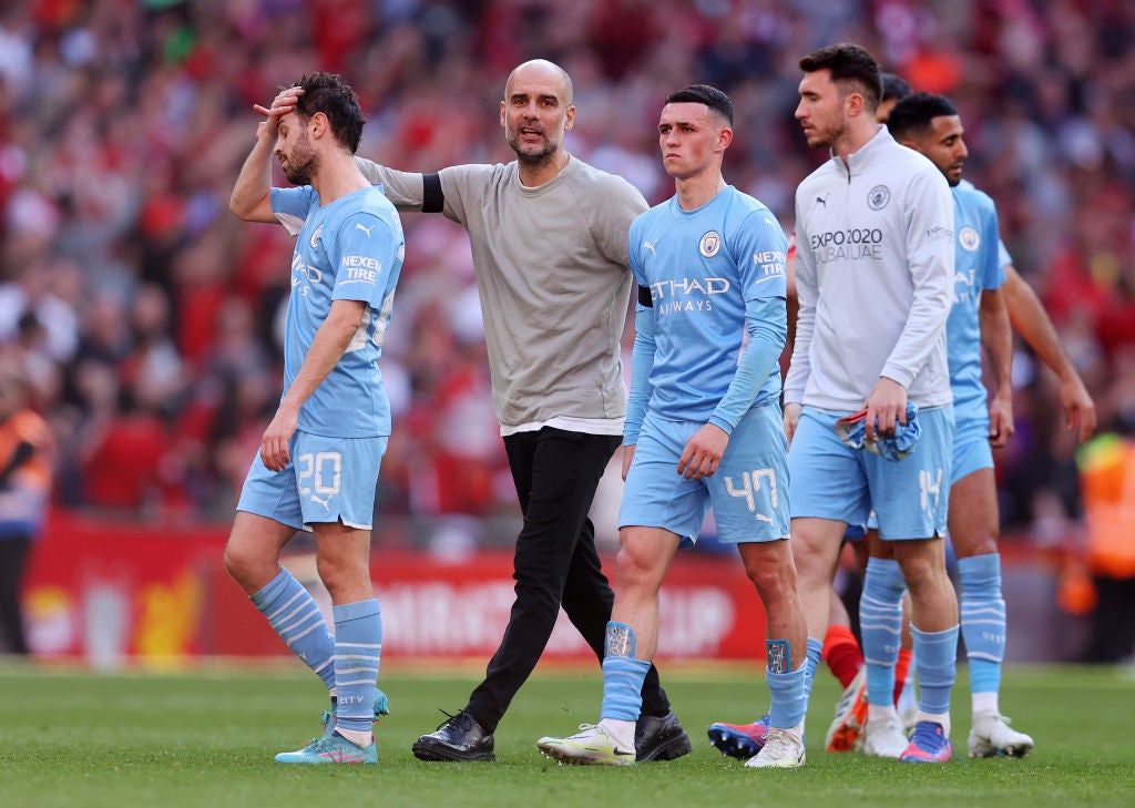 Pep Guardiola consoles his players after defeat by Liverpool in the FA Cup