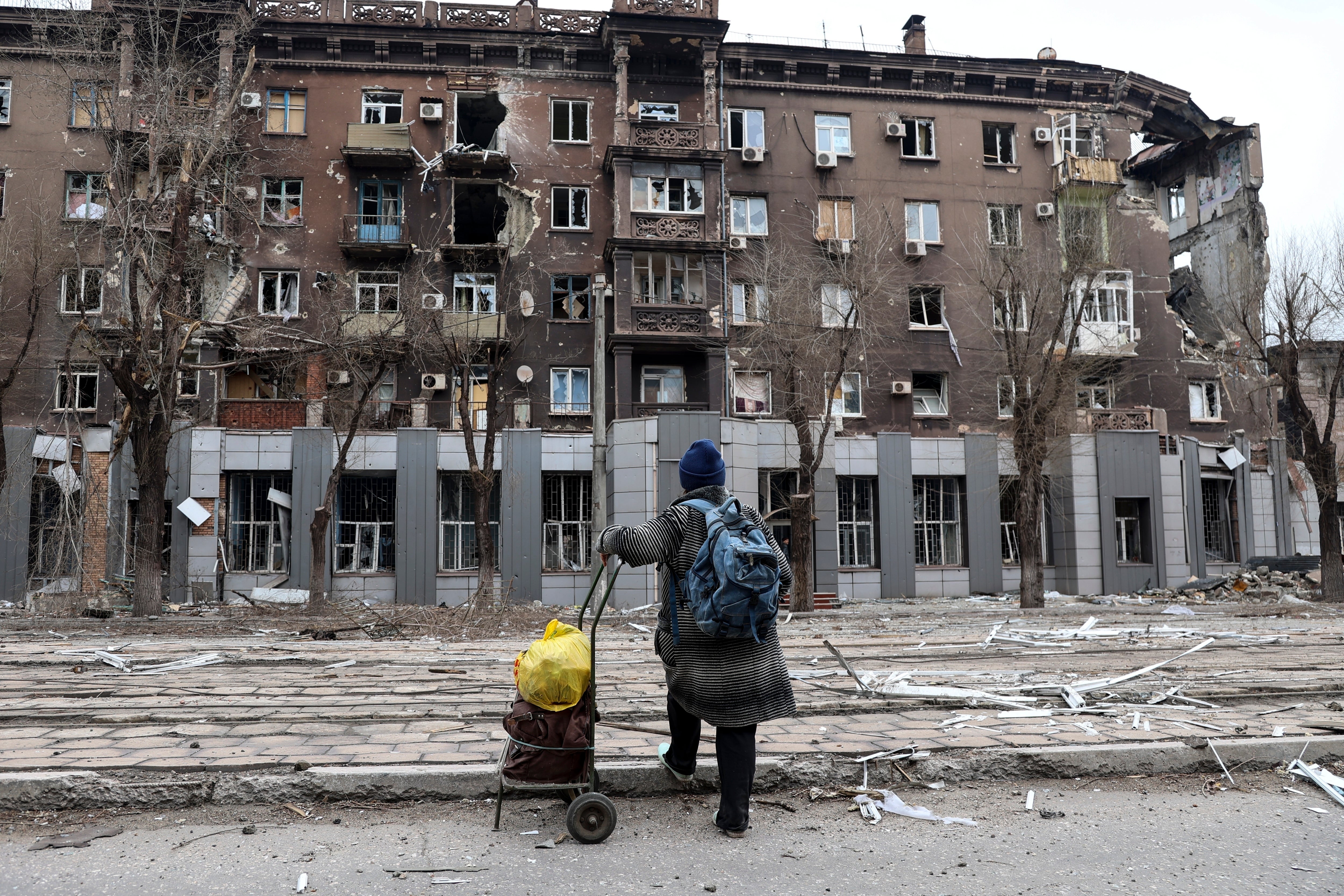 A local resident looks at a damaged during a heavy fighting apartment building near the Illich Iron & Steel Works Metallurgical Plant, the second largest metallurgical enterprise in Ukraine, in an area controlled by Russian-backed separatist forces in Mariupol