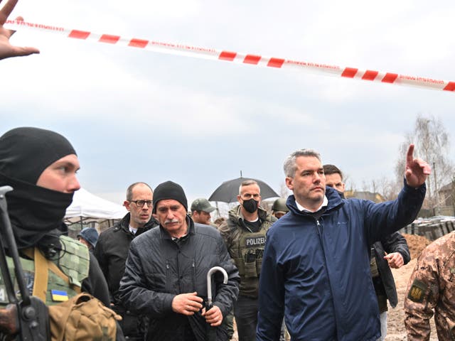 <p>Austrian Chancellor Karl Nehammer (R) leaves after visiting the site of a mass grave in the Ukrainian town of Bucha, near Kyiv on 9 April 2022</p>