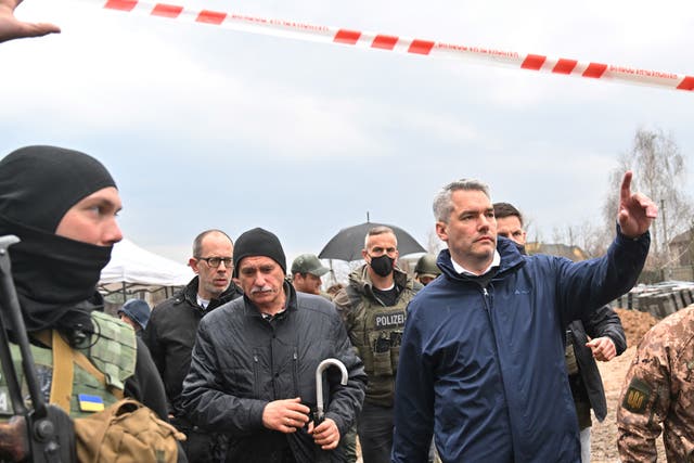 <p>Austrian Chancellor Karl Nehammer (R) leaves after visiting the site of a mass grave in the Ukrainian town of Bucha, near Kyiv on 9 April 2022</p>