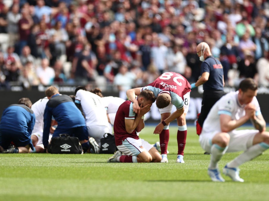 West Ham’s Nikola Vlasic is in tears while Ashley Westwood of Burnley receives treatment