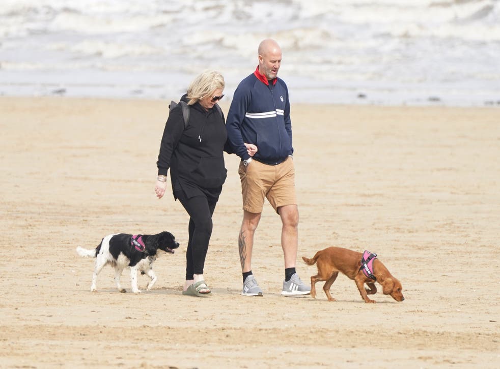 People walking dogs on Bridlington Beach in Yorkshire (PA)