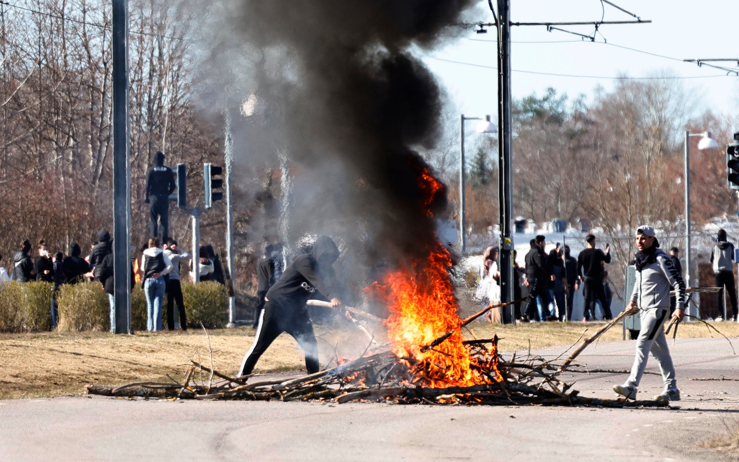 People burn branches to block a road during a riot in Norrkoping