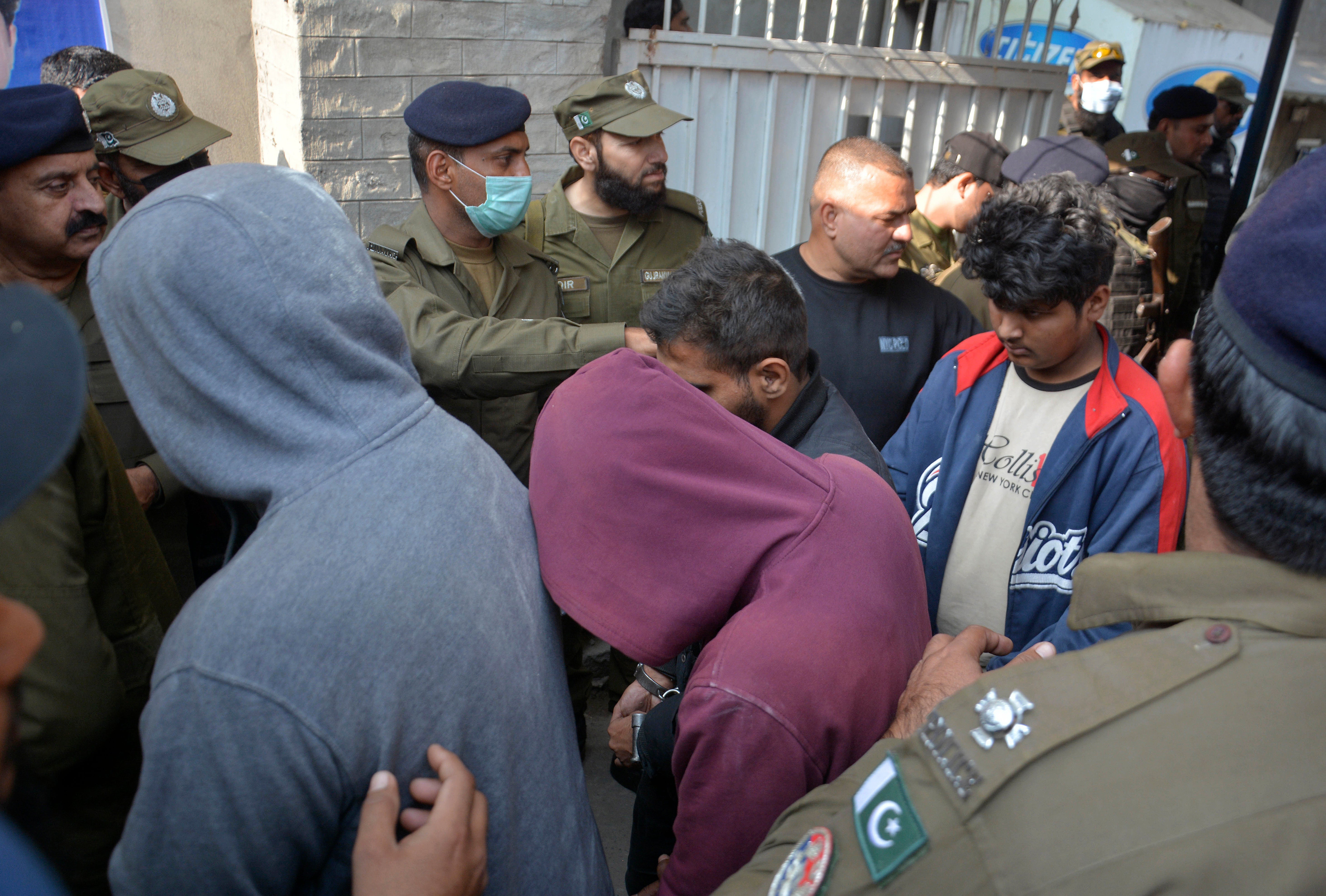 File photo: Police officers escort suspects involved in the killing of Priyantha Kumara