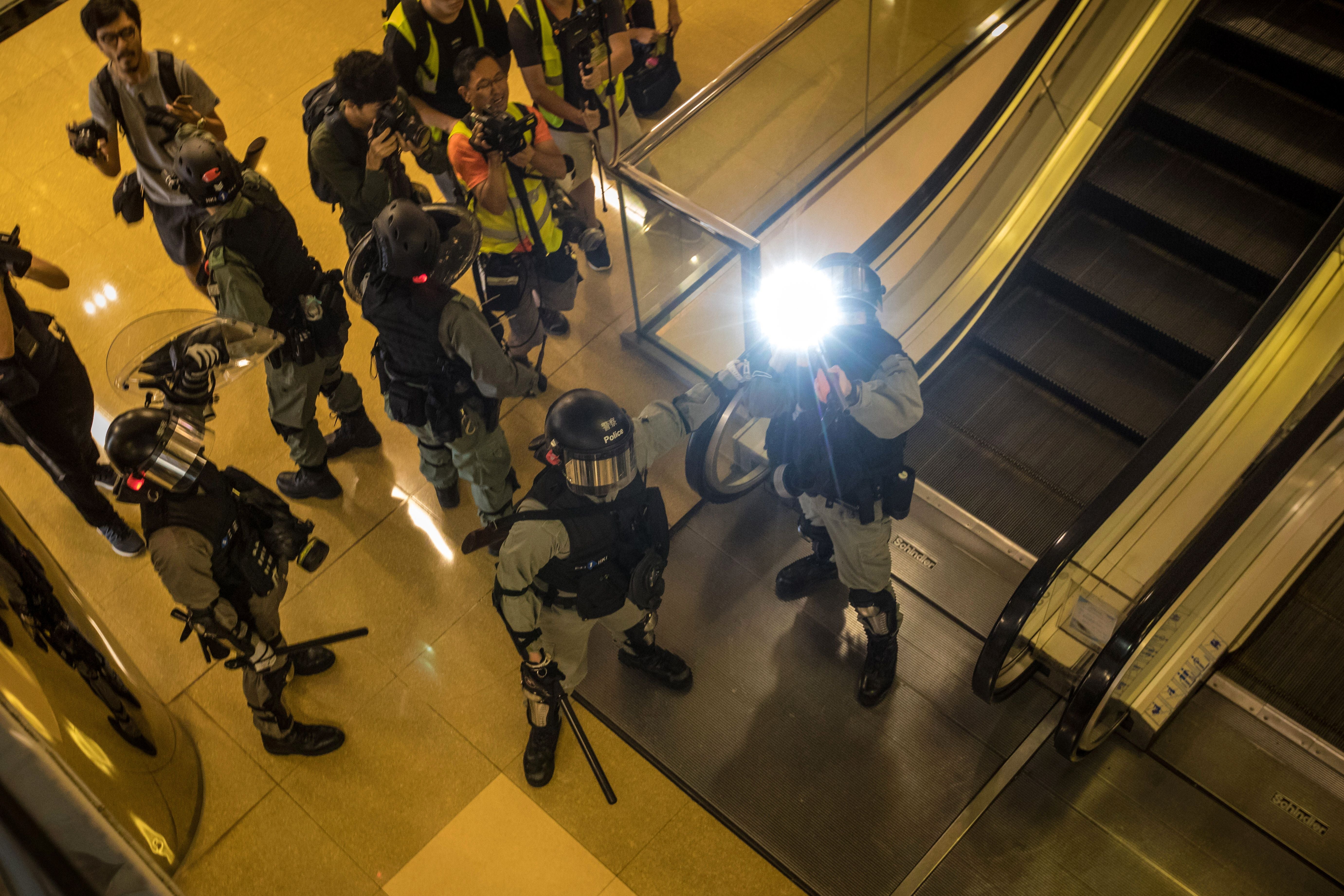 File: Riot police search for protesters inside the City Plaza mall in the Tai Koo Shing area in Hong Kong after a bloody knife fight wounding six people