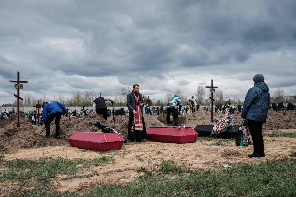 Putin awards medals to soldiers accused of Bucha massacre as victims buried in mass graves