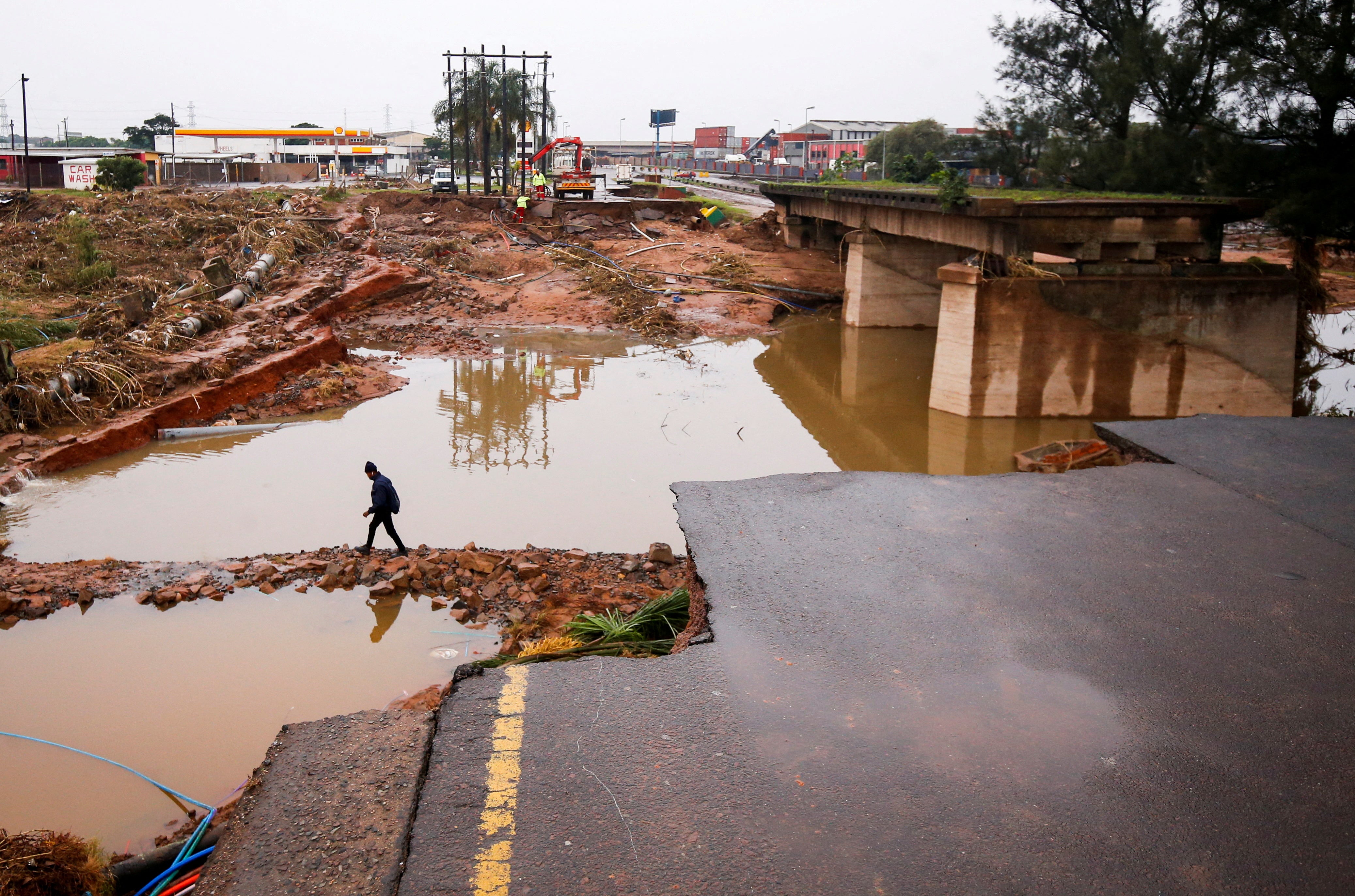A man walks around a damaged bridge caused by flooding in Umlazi near Durban, South Africa