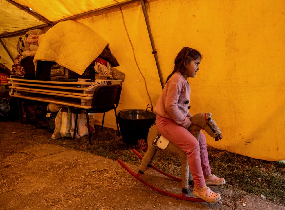 <p>A refugee girl sit on a swing horse in a temporary shelter offered by the Free Christian Church in Uszka, Hungary</p>