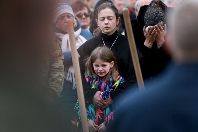 <p>Christina Dragun hugs her daughter Olya Siksoy during the burial of her husband Ukrainian soldier Ruslan Siksoy at the Lychakiv Cemetery in Lviv, Ukraine. Siksoy was killed while fighting against the Russian military in the Donbas area</p>
