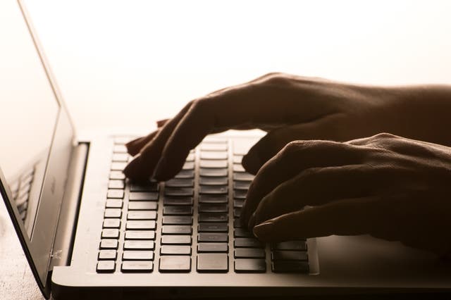 A woman’s hands on a laptop keyboard.