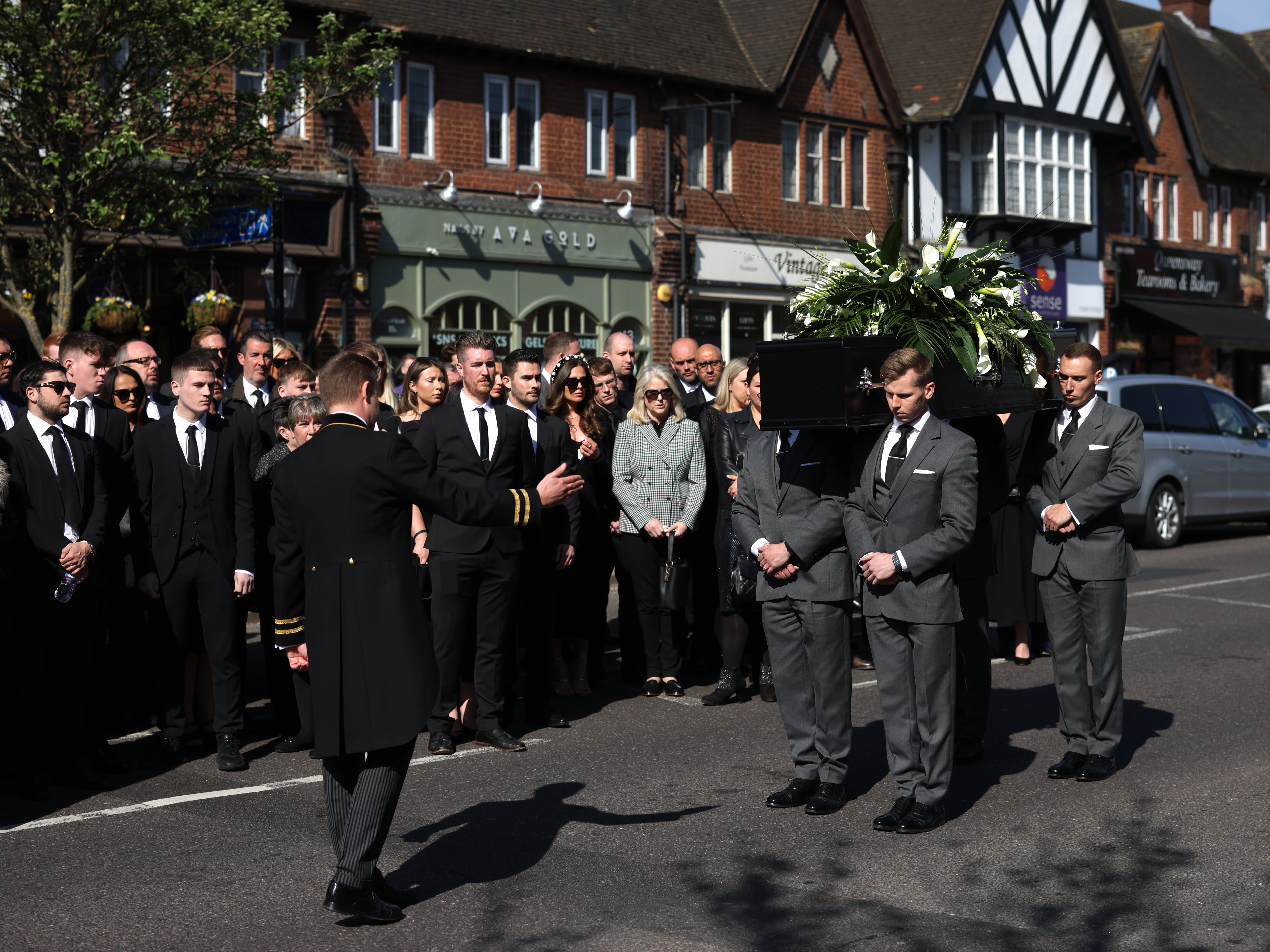 Tom Parker’s coffin is held aloft as it is carried into St Francis of Assisi church in Orpington, England