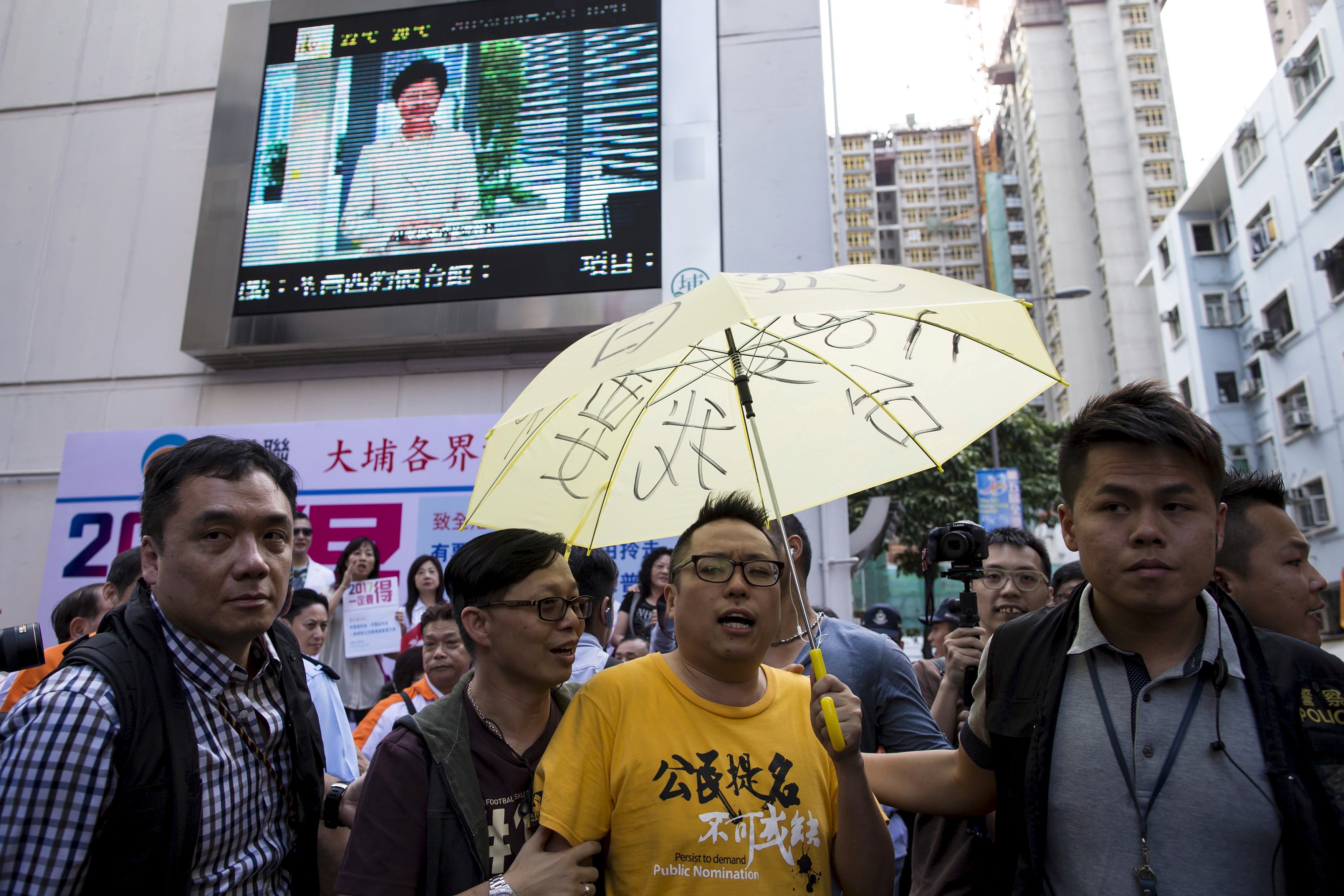 <p>Tam is escorted away by police at a protest in 2015 </p>