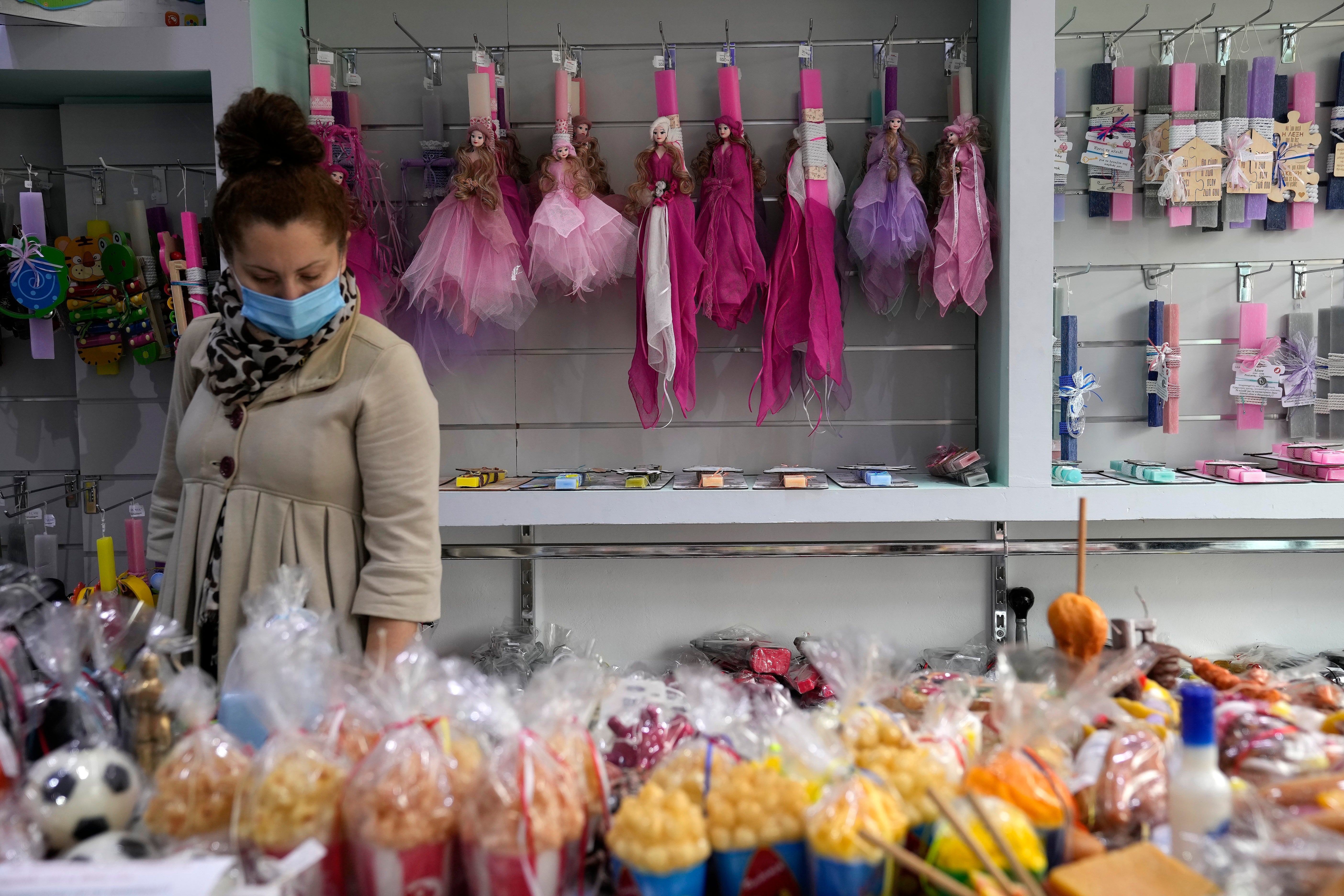 A woman checks out candles in a store in Athens, Greece