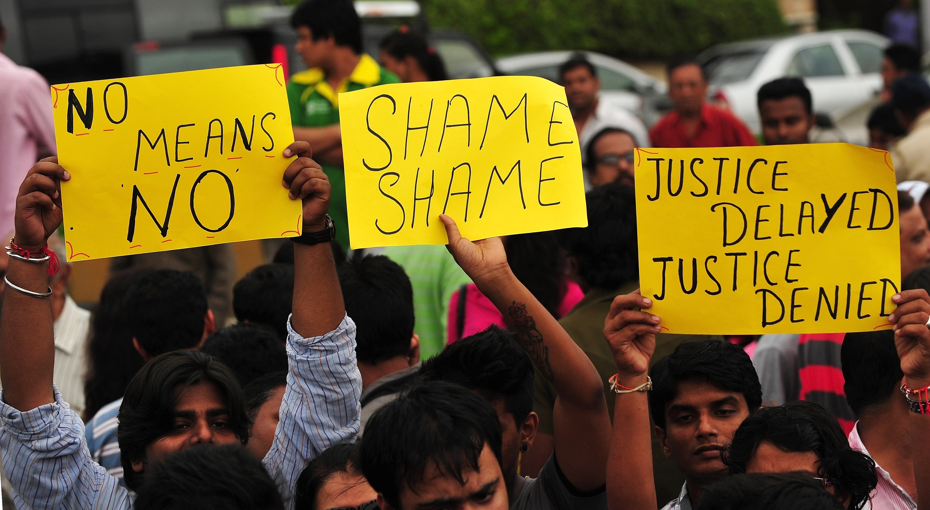 File photo: Indian activists hold posters during a protest march against the gang-rape of a photographer in Mumbai on 25 August 2013