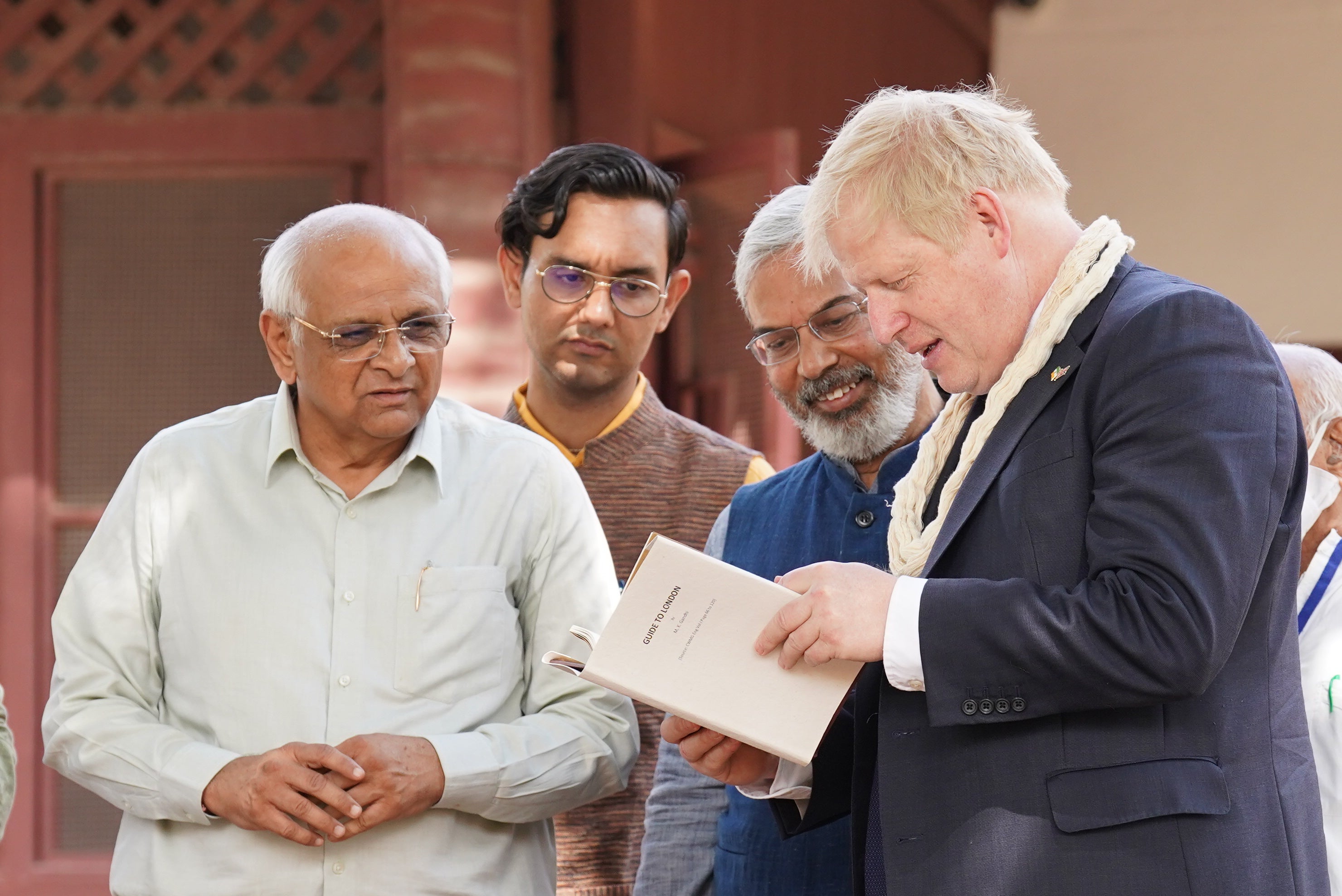 Prime Minister Boris Johnson is shown a copy of Gandhi’s London guide (Stefan Rousseau/PA)