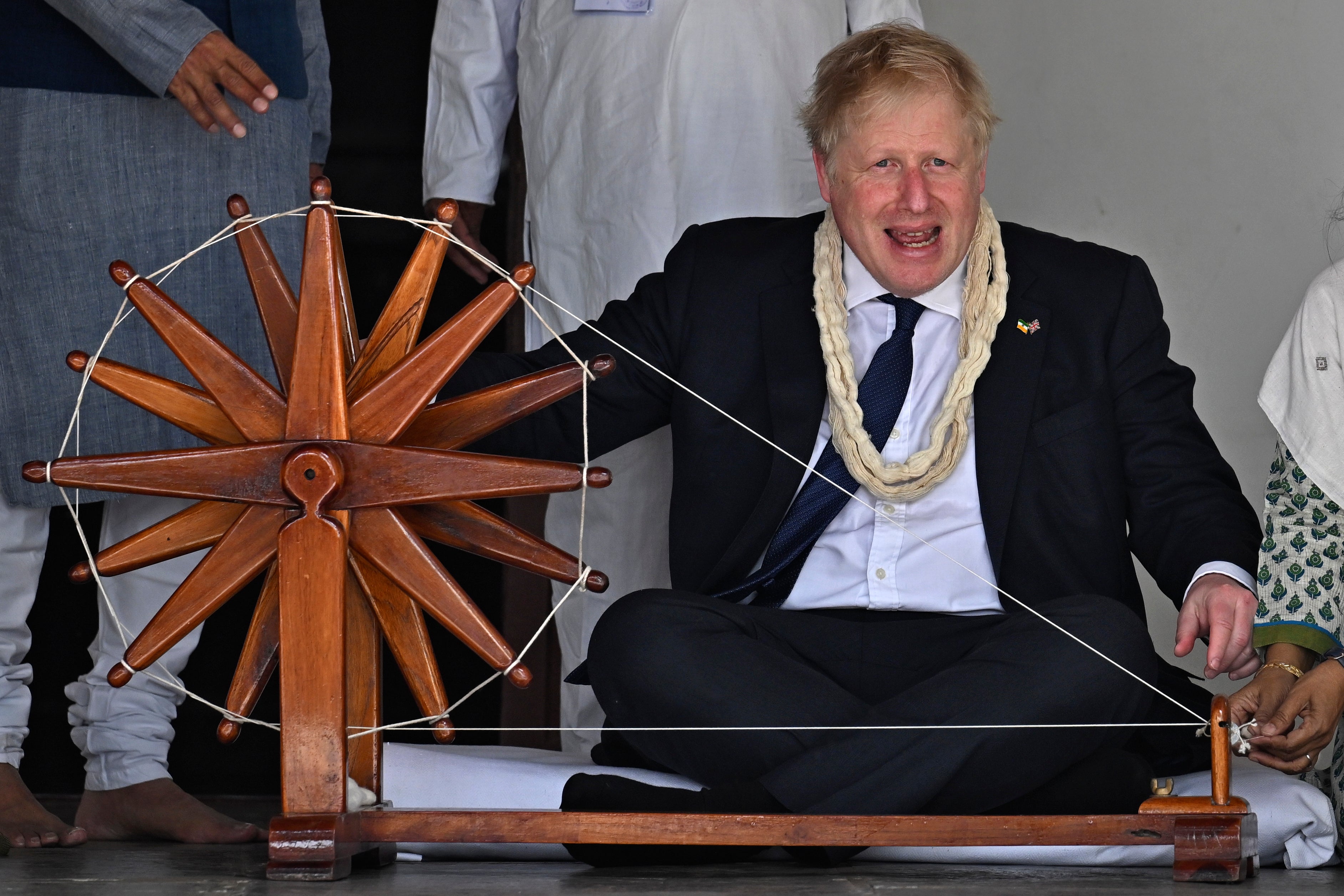 Boris Johnson spins khadi on a spinning wheel during his visit at the Gandhi Ashram