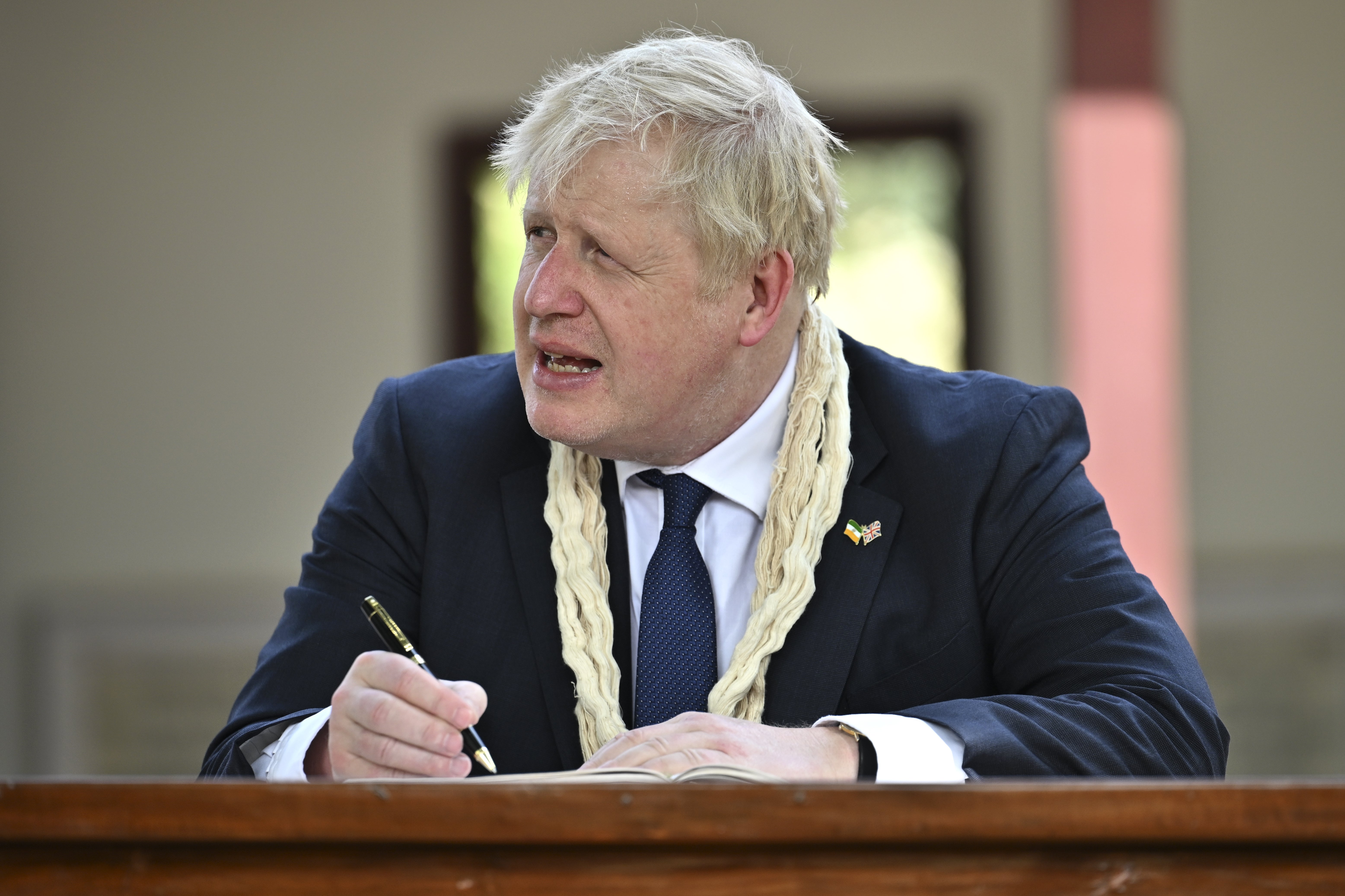 Prime Minister Boris Johnson writes in the visitors’ book during his visit to Mahatma Gandhi’s Sabarmati Ashram in Ahmedabad, as part of his two day trip to India (Stefan Rousseau/PA)