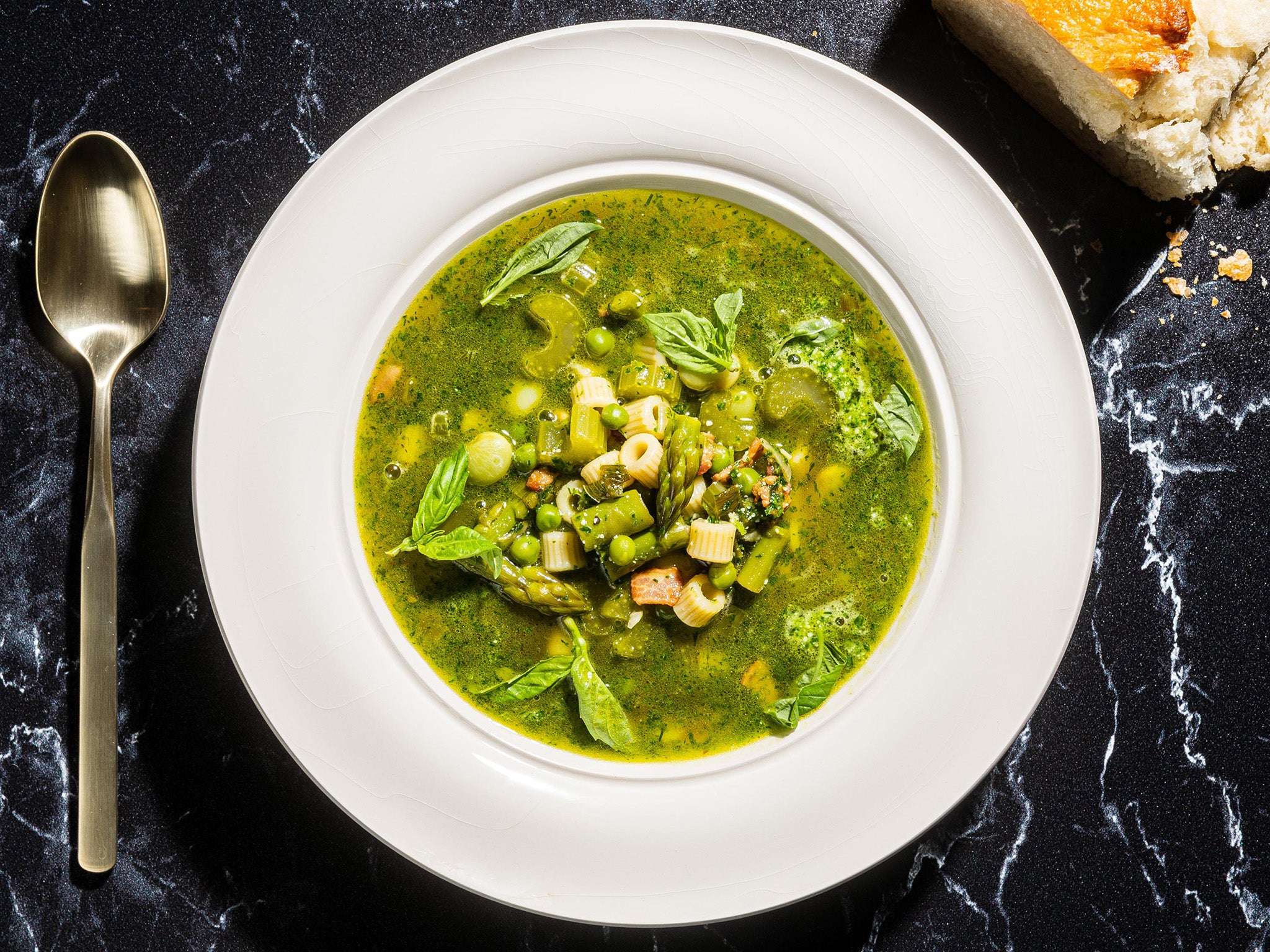 This minestrone, thick with spring vegetables, is tinted green with an herb pesto swirled into each bowl before serving