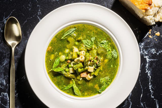 <p>This minestrone, thick with spring vegetables, is tinted green with an herb pesto swirled into each bowl before serving</p>