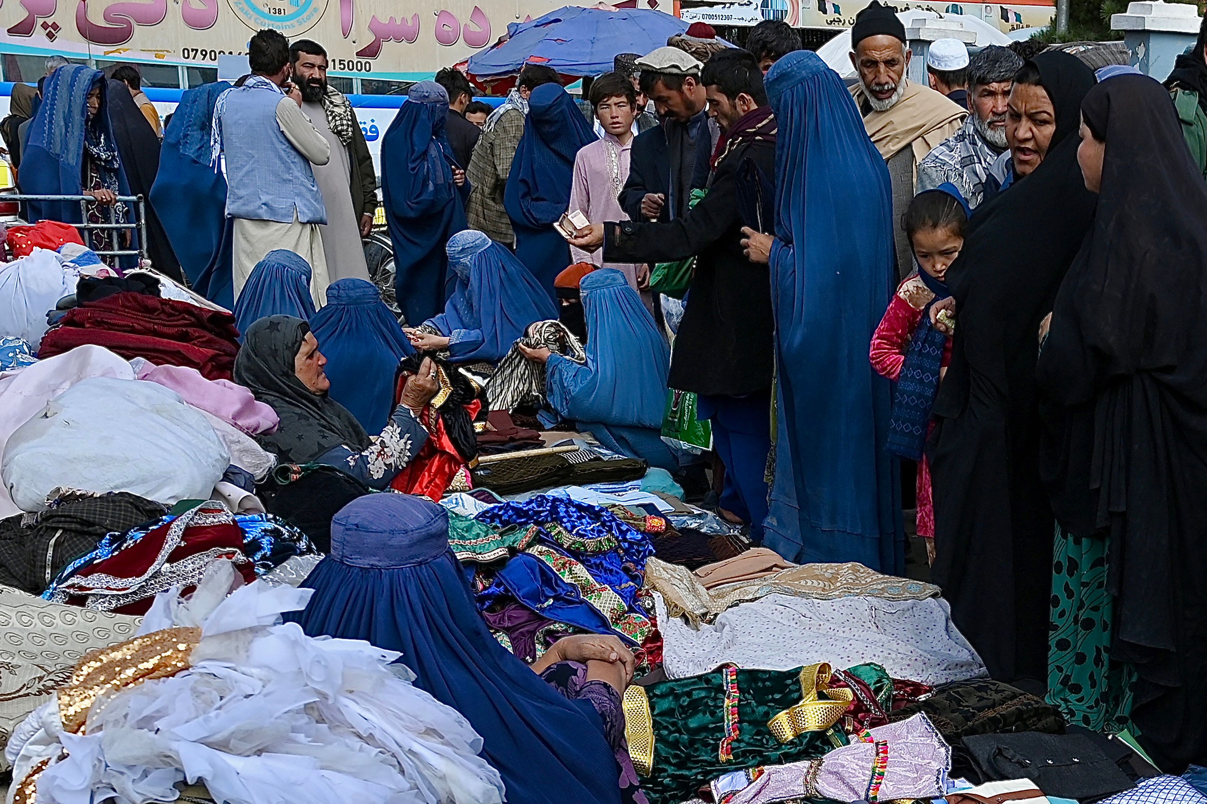 File photo: Women wearing a burqa sell clothes along a roadside in Mazar-i-Sharif on 31 October