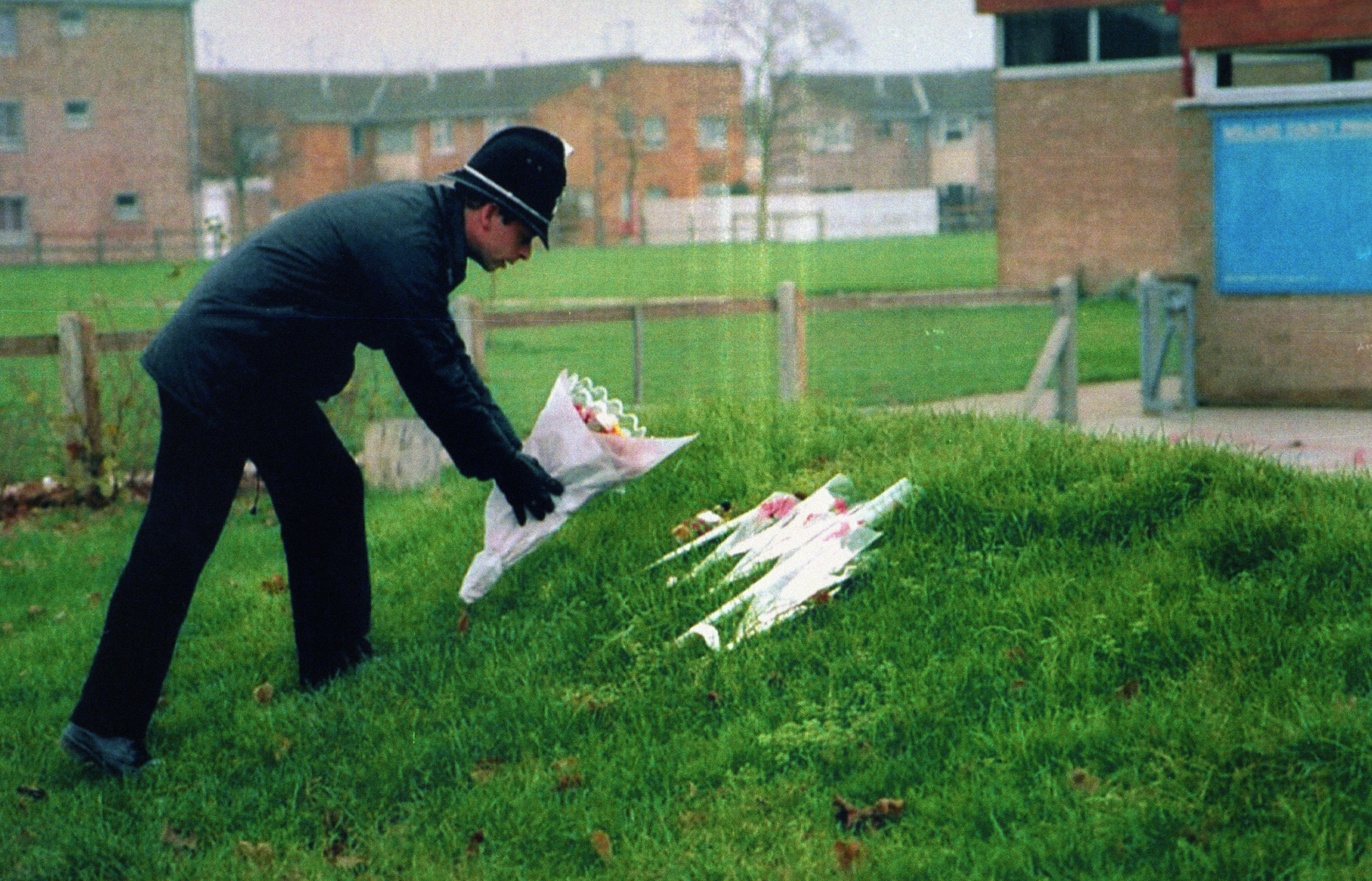 A policeman leaving flowers at Welland County Primary School in Peterborough, the school of murdered six-year-old Rikki Neave.