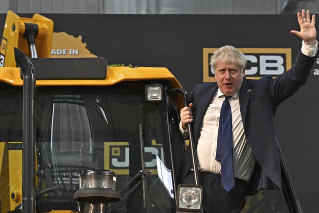 Prime Minister Boris Johnson waves from a JCB at the new JCB Factory in Vadodara, Gujarat, during his two day trip to India (Ben Stansall/PA)