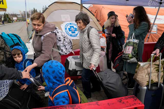 Refugees wait in a line after fleeing the war from neighboring Ukraine at the border crossing in Medyka, southeastern Poland, Sunday, April 10, 2022. (AP Photo/Sergei Grits)