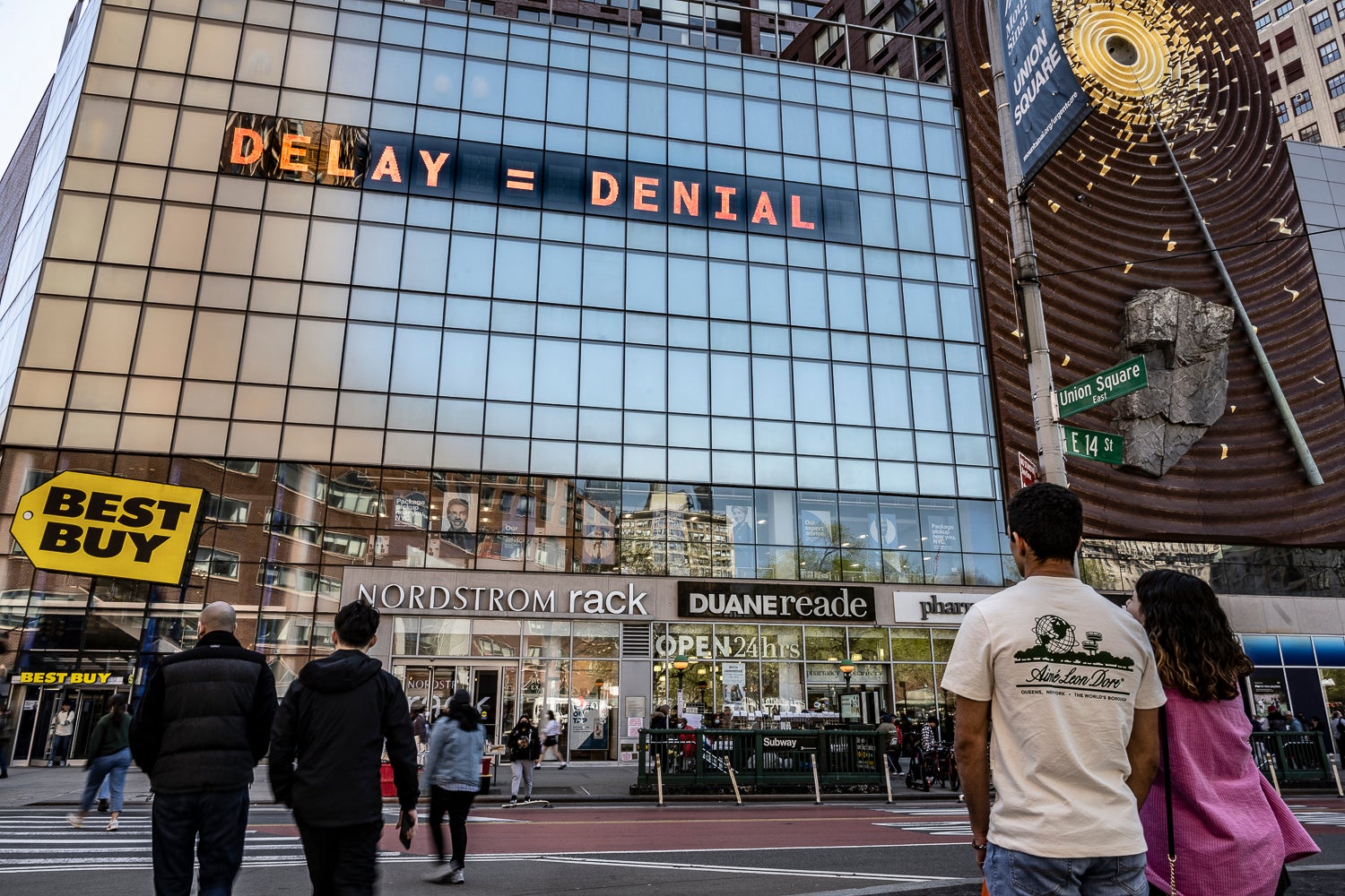 <p>Pedestrians look up at the CLIMATE CLOCK in New York City.</p>