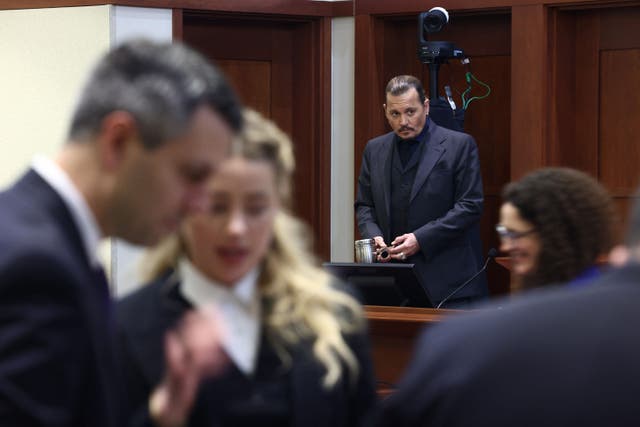 <p>US actress Amber Heard (2L) speaks to her legal team as US actor Johhny Depp stands (2R) during the 50 million US dollar Depp vs Heard defamation trial at the Fairfax County Circuit Court in Fairfax, Virginia, April 21, 2022</p>
