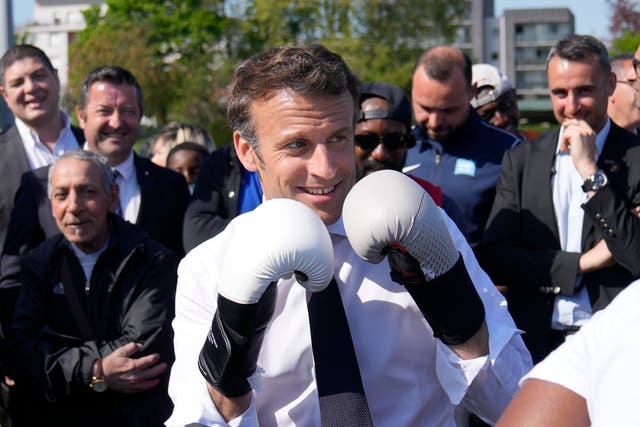 <p>French president Emmanuel Macron wears boxing gloves on the campaign trail on 21 April 2022 </p>