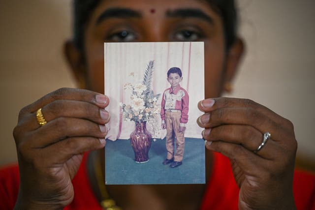 <p>Sarmila Dharmalingam, the elder sister of Nagaenthran Dharmalingam, displays a photo of her brother</p>