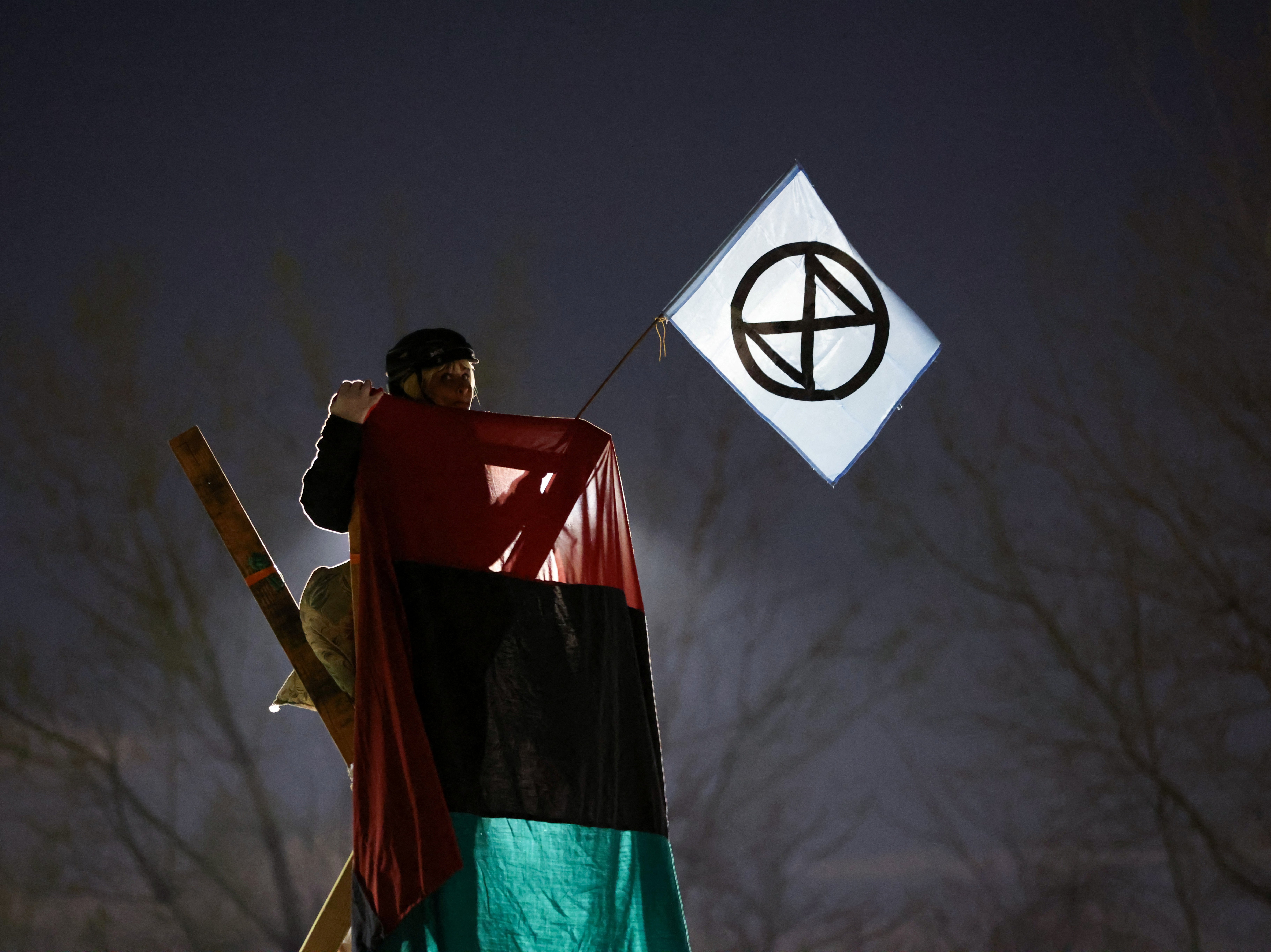 An activist from Extinction Rebellion takes part in an Earth Day demonstration blockading the gate of the New York Times Distribution print facility