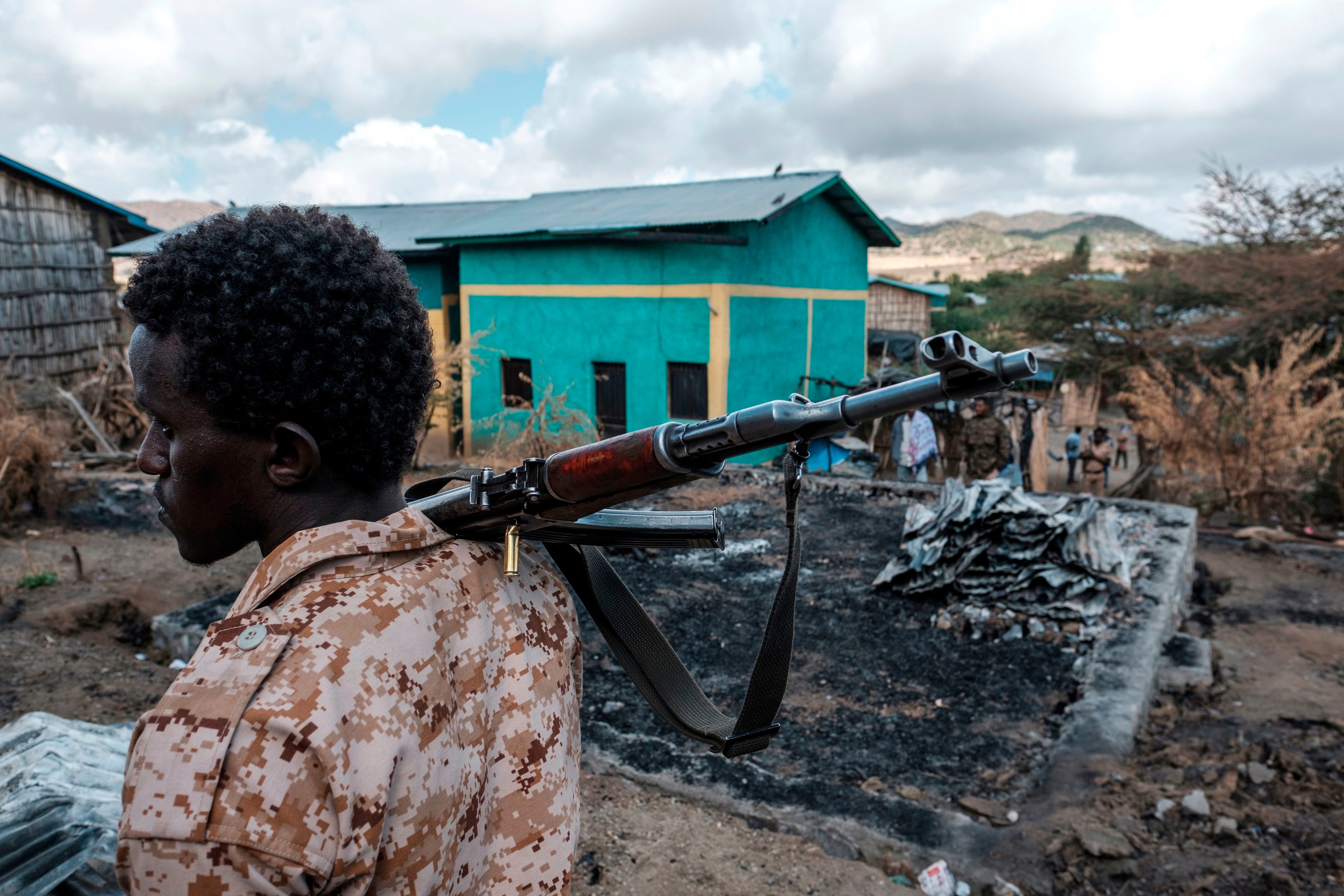 File photo: A member of the Afar Special Forces holds a gun next to a damaged house in the village of Bisober in Tigray in December 2020