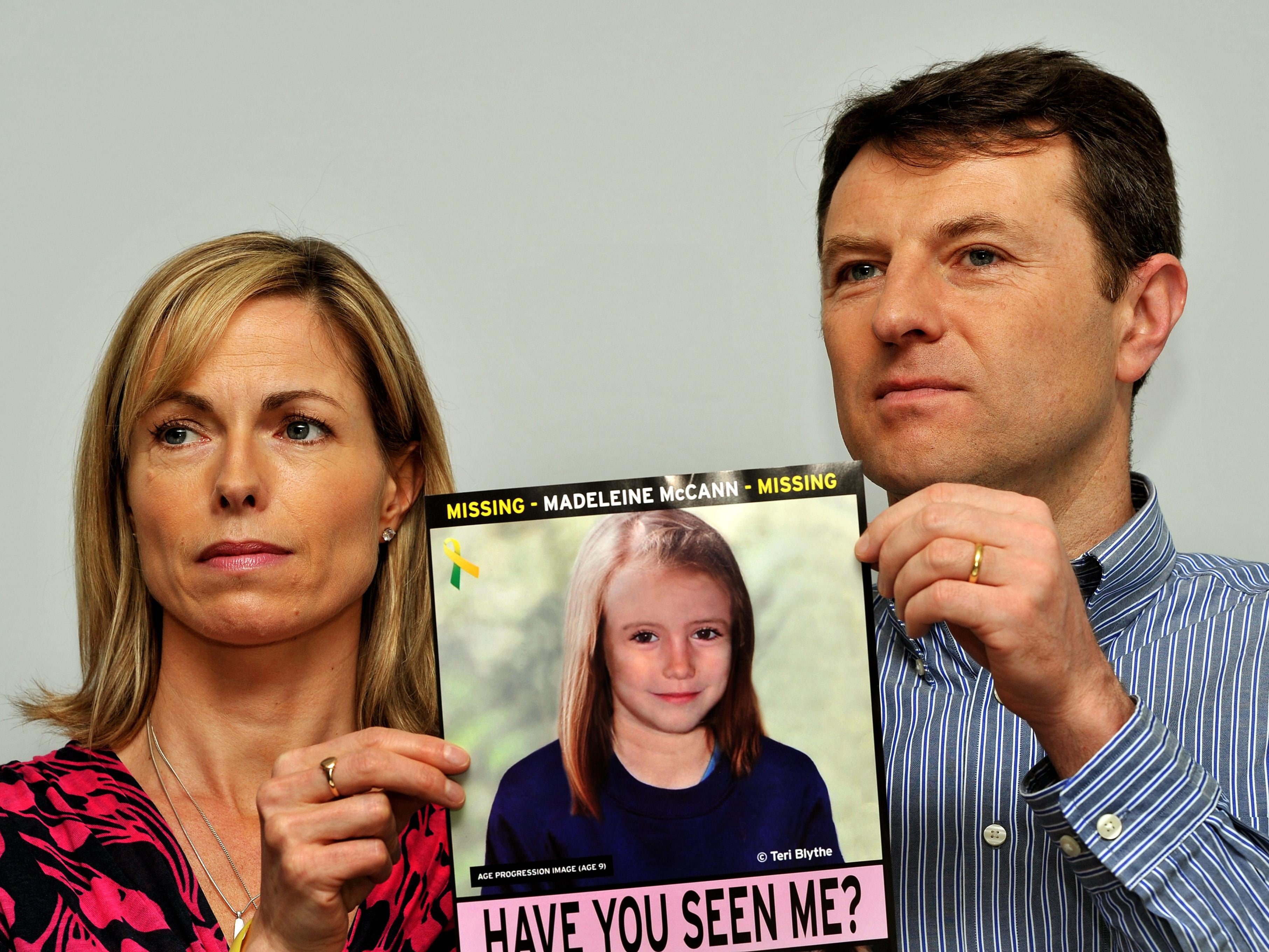 Kate and Gerry McCann with a missing person poster showing an image of what Madeleine might have looked like aged 9