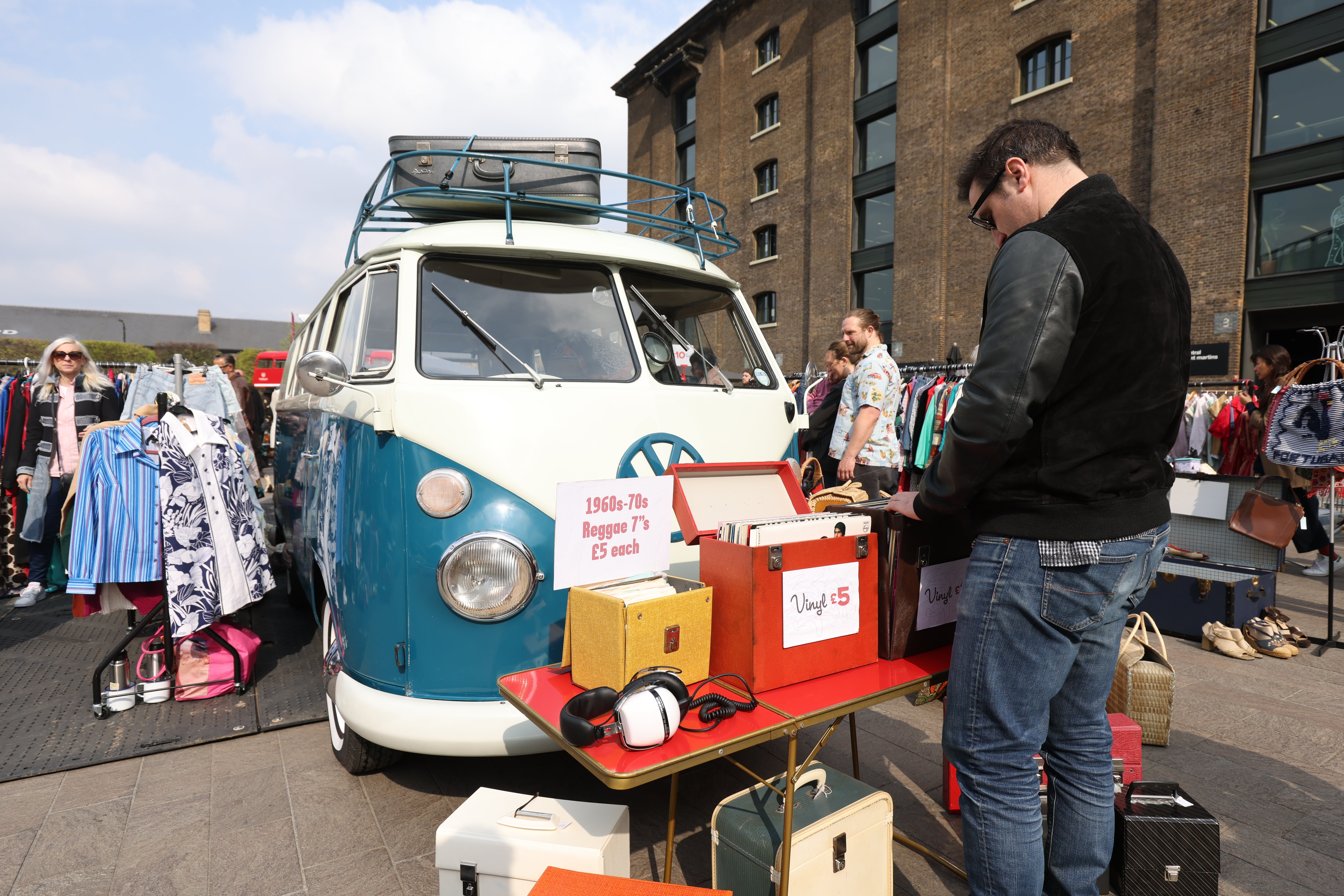 A man browses vinyl records in front of a 1965 VW Campervan (James Manning/PA)
