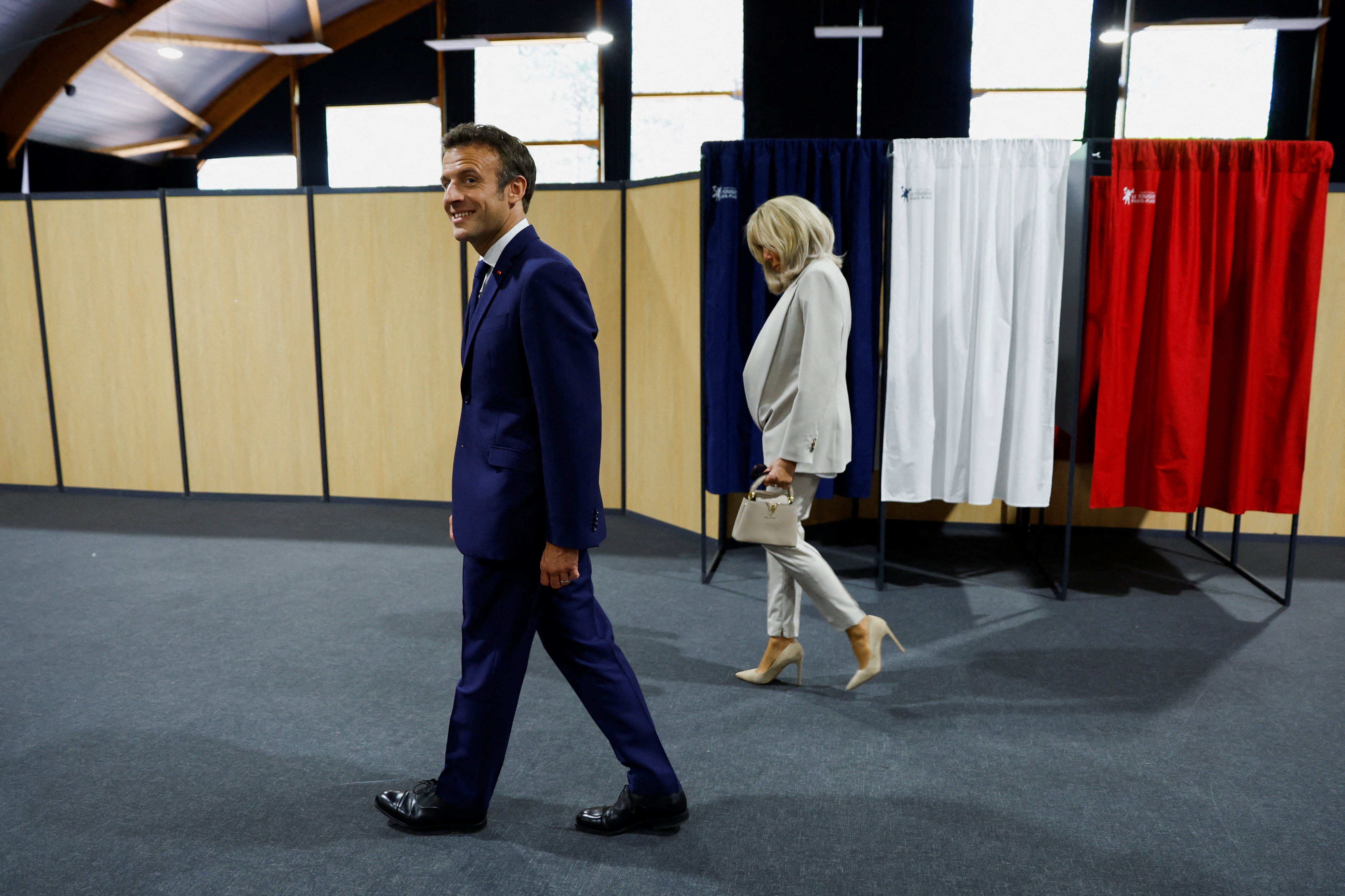 French President Emmanuel Macron, candidate for his re-election, and his wife Brigitte Macron arrive to vote in the second round of the 2022 French presidential election, at a polling station in Le Touquet-Paris-Plage