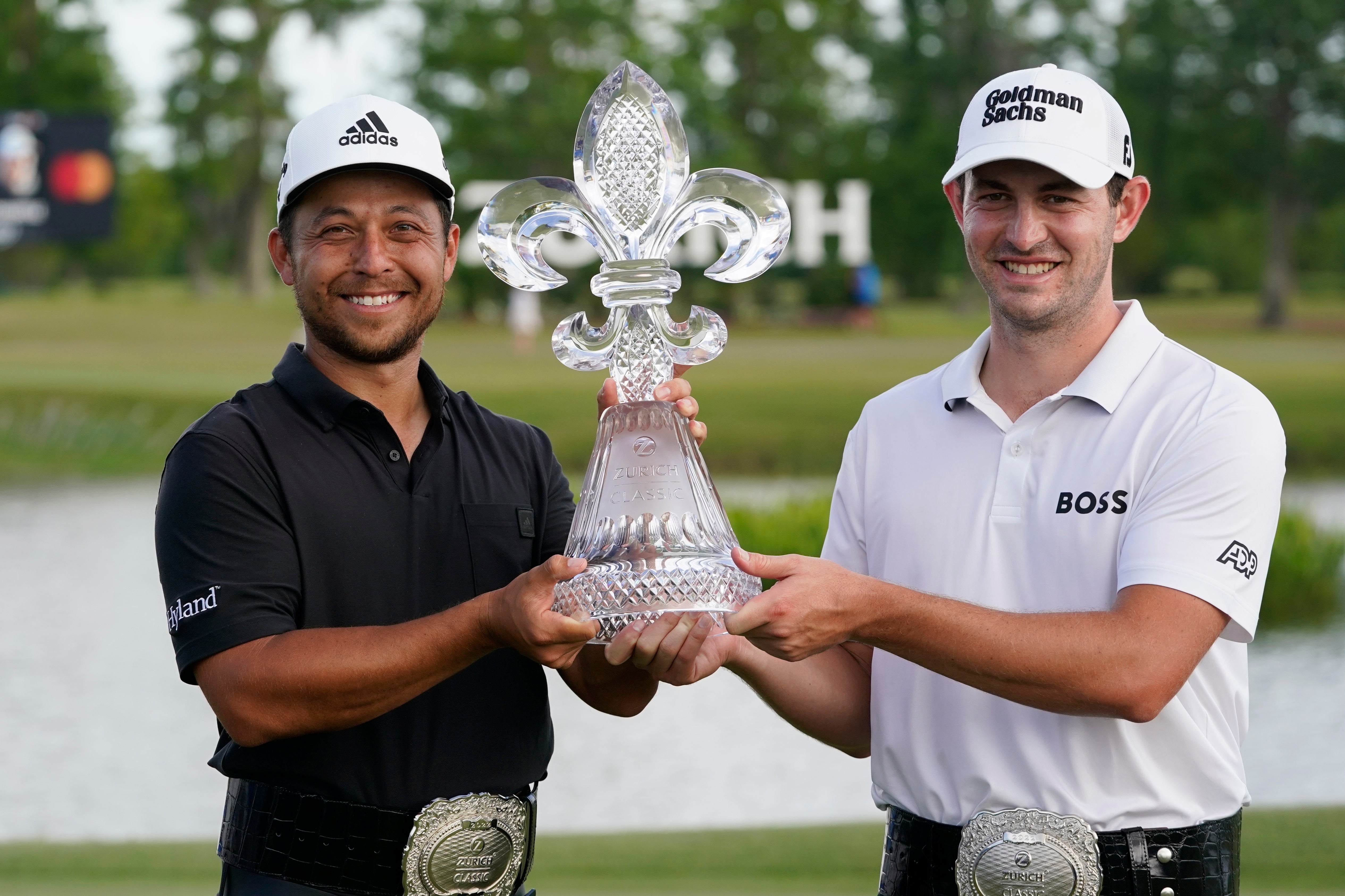 Xander Schauffele, left, and Patrick Cantlay, right, hold up the trophy after winning the PGA Zurich Classic golf tournament at TPC Louisiana (AP Photo/Gerald Herbert)