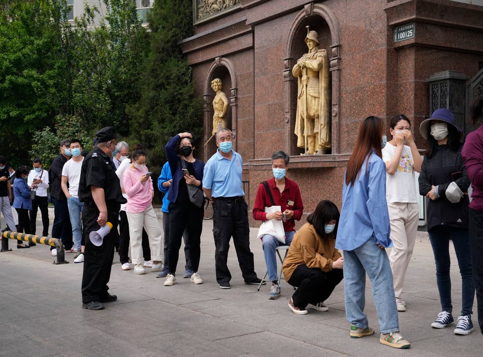 <p>Residents wearing masks line up for mass Covid testing in Chaoyang District on Monday in Beijing</p>